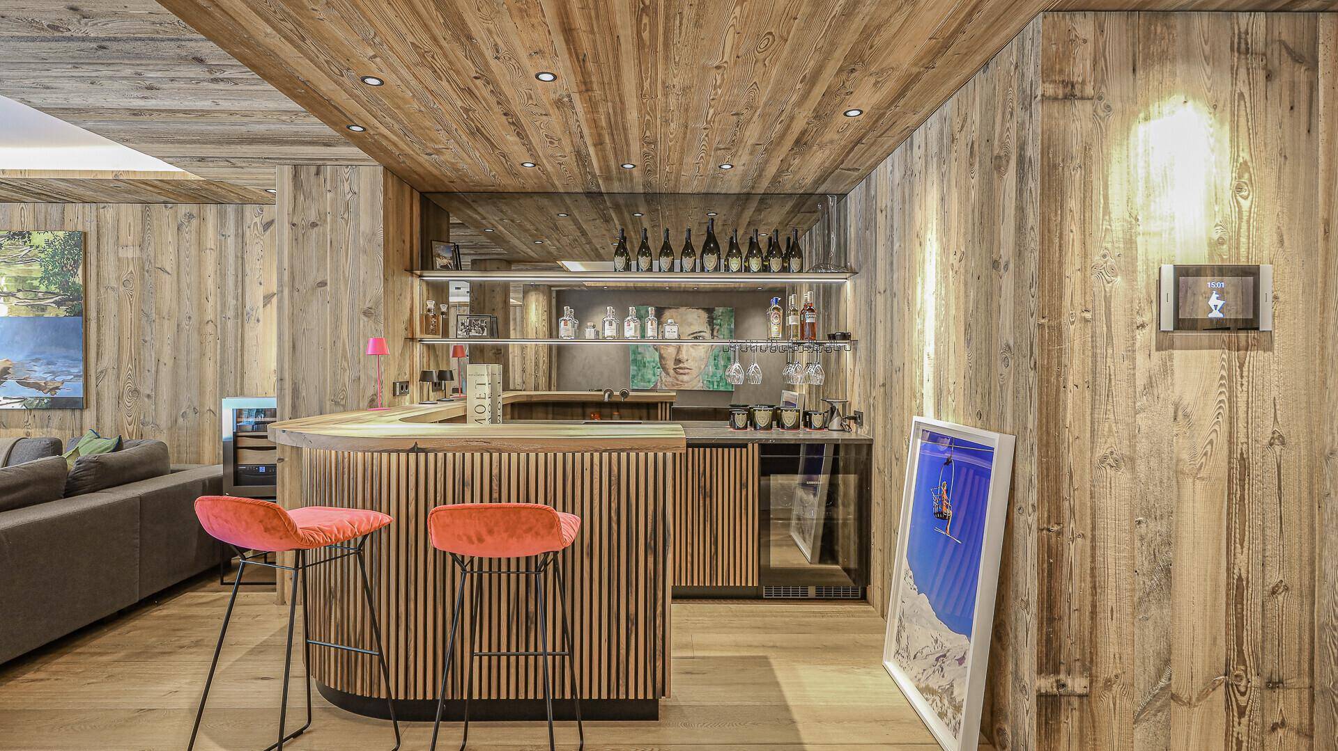 Elegante Hausbar mit Holzvertäfelung, integrierten Regalen und modernen Barhockern.