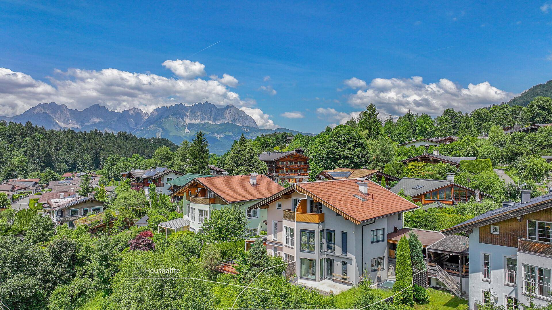 Übersicht des Anwesens mit Grundstücksgrenzen und Panoramablick auf die umliegende Berglandschaft.