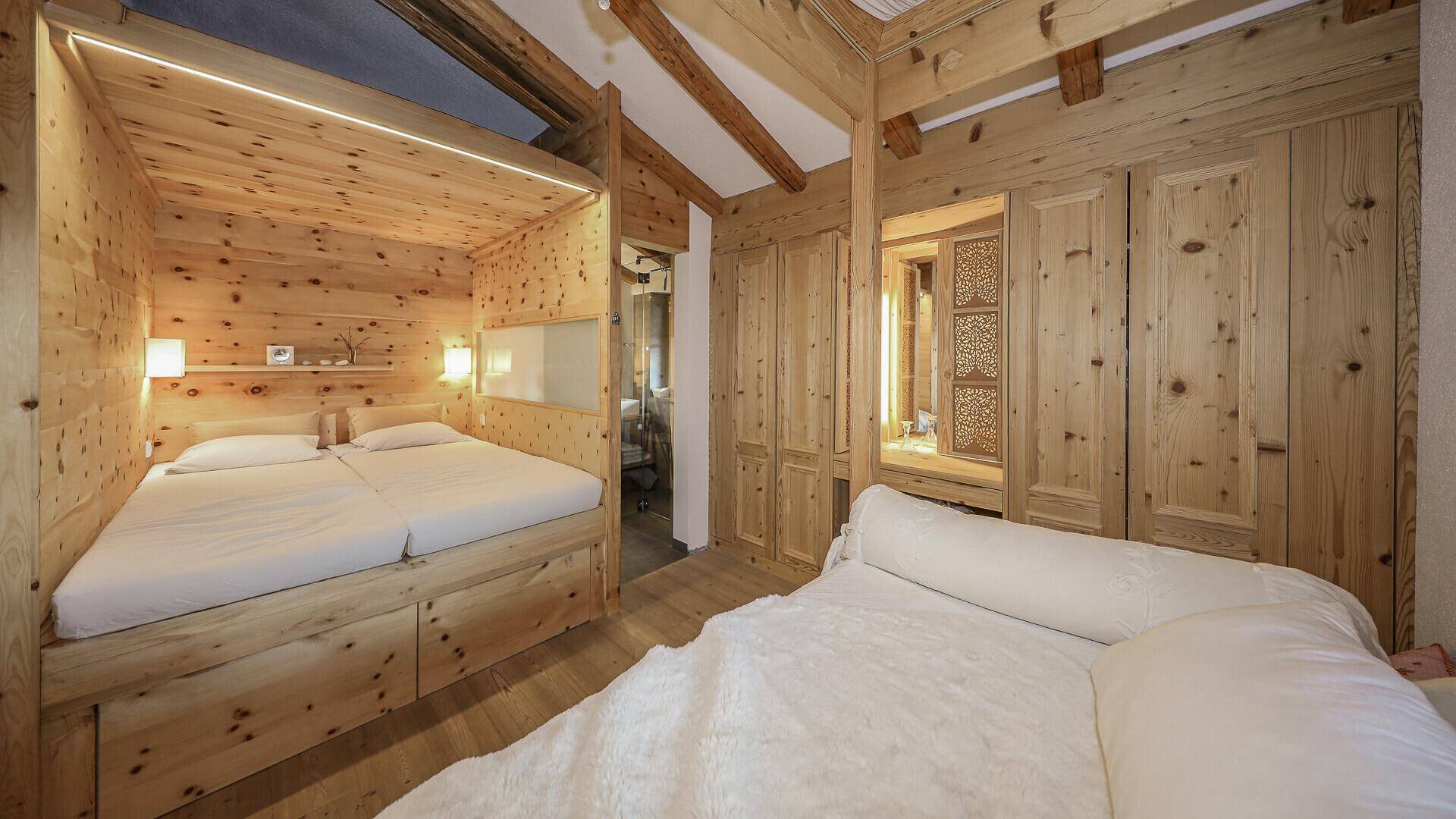 Schlafzimmer mit eingebautem Holzbett, Holzwänden und Schränken, bietet eine gemütliche Atmosphäre.