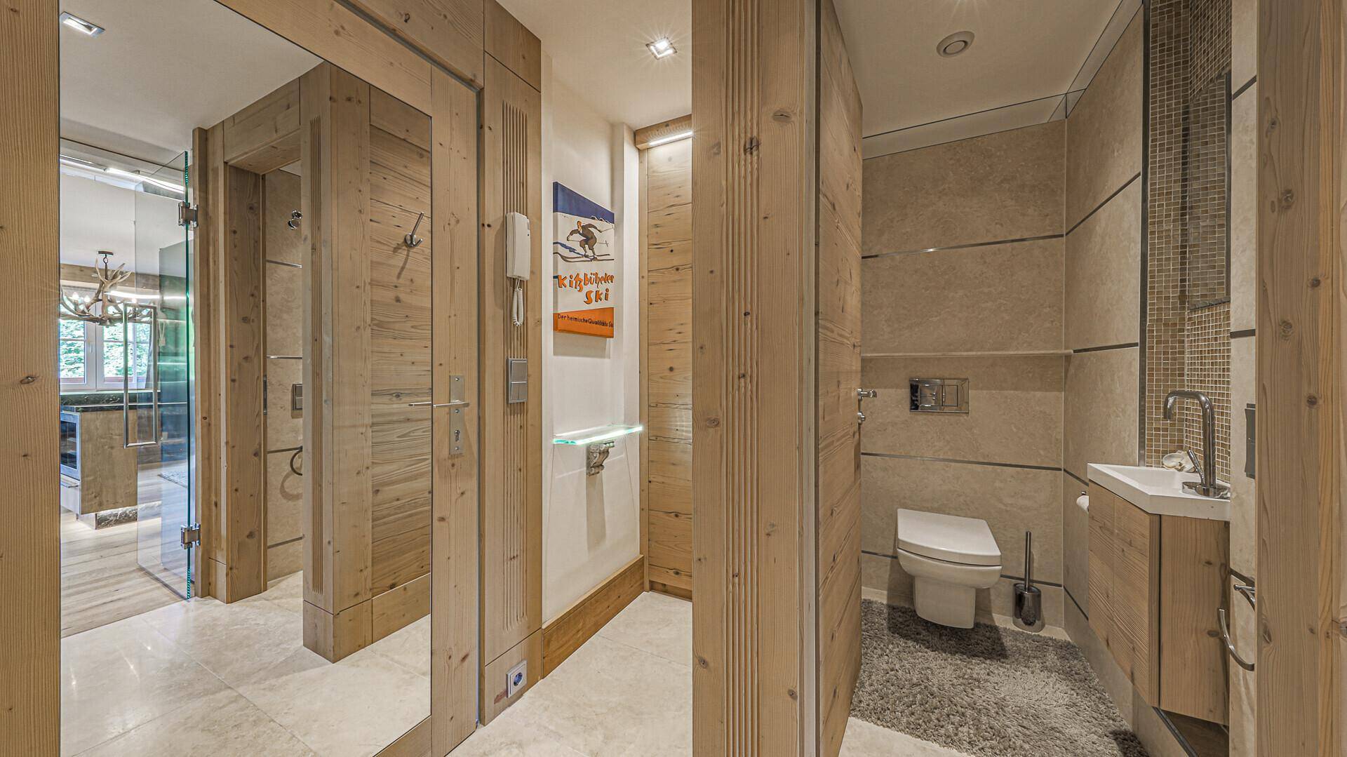 Modernes Gäste-WC mit Holzwänden, Wand-WC und kleinem Waschbecken.
