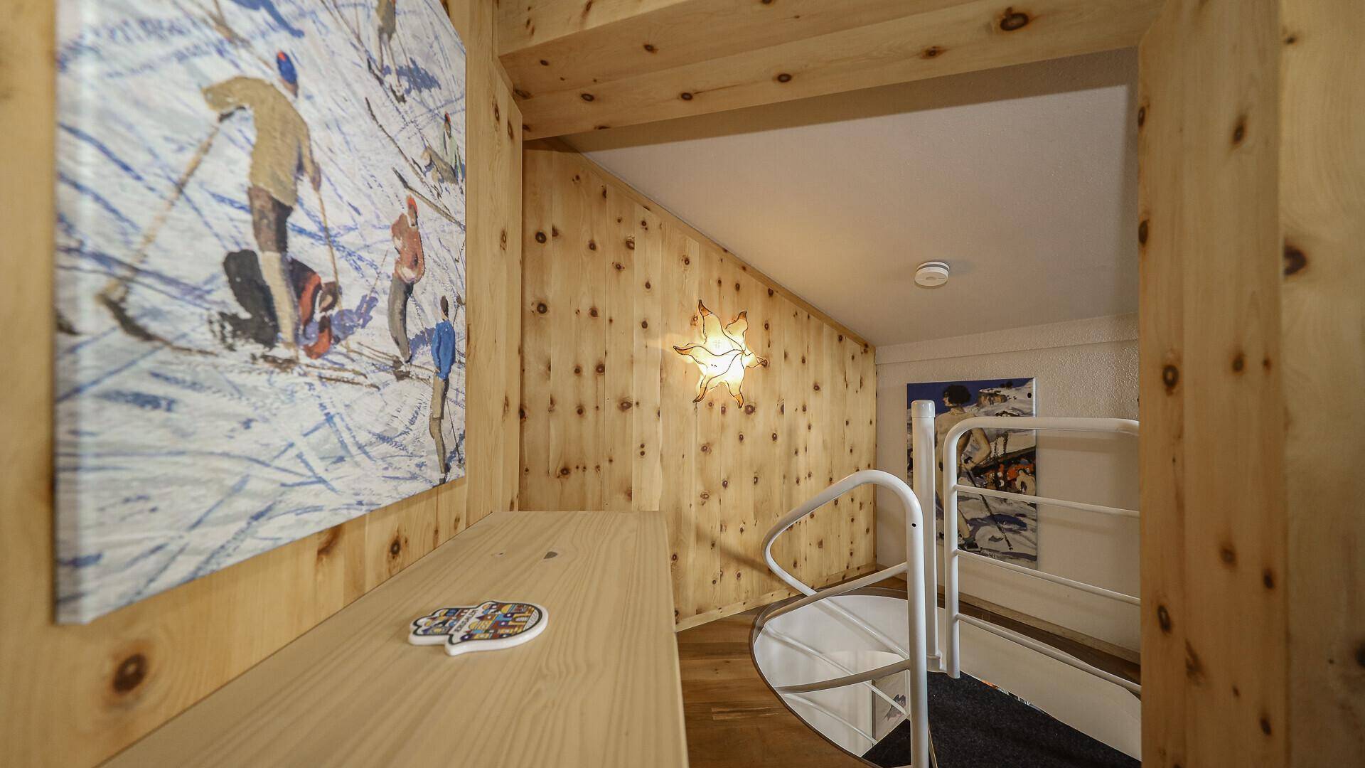 Gemütlicher Bereich mit Holzvertäfelung und Zugang zu einer Wendeltreppe.