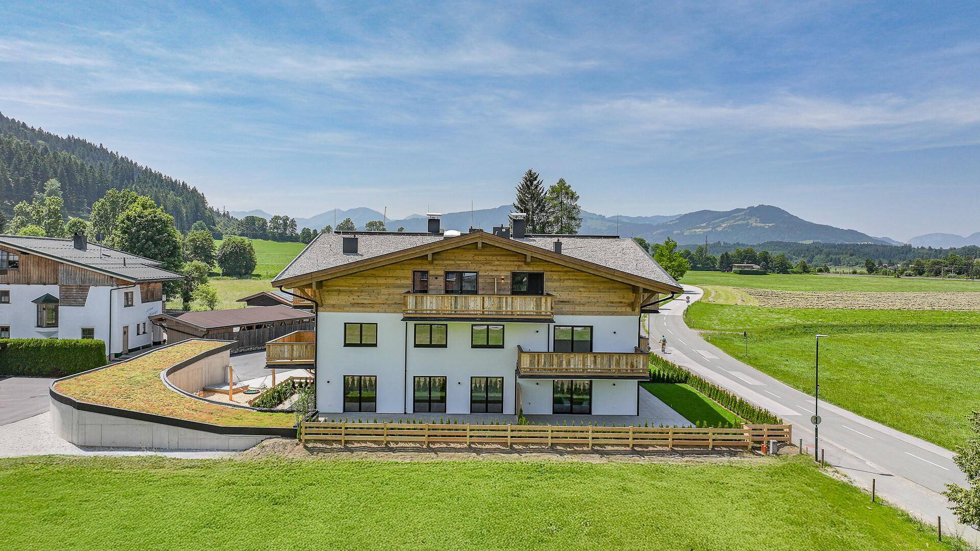 Rückansicht des Wohnhauses mit grüner Dachfläche und weitem Blick über die Landschaft.