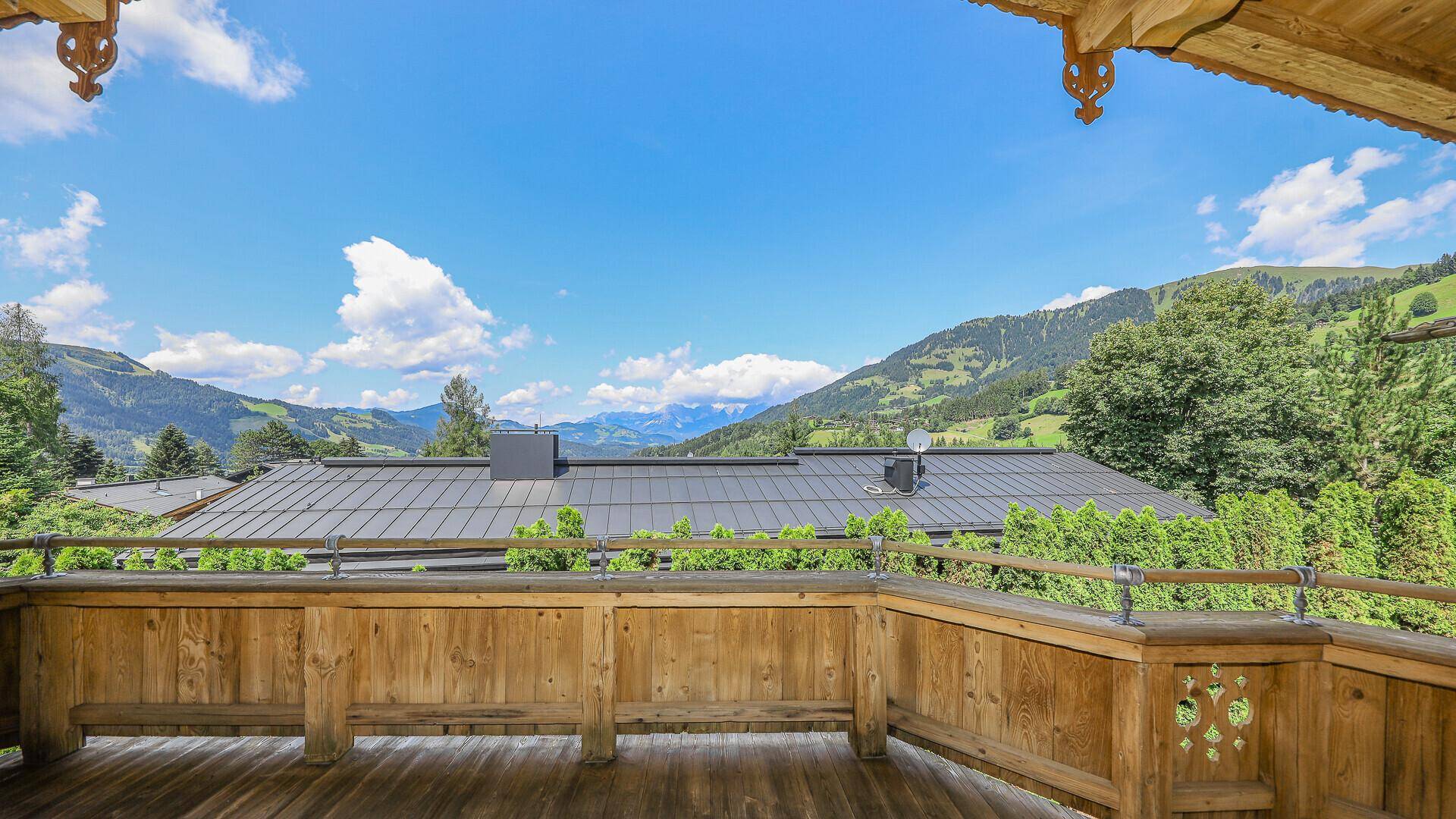 Geräumiger Holzbalkon mit traditionellen Schnitzereien und weitem Bergblick.