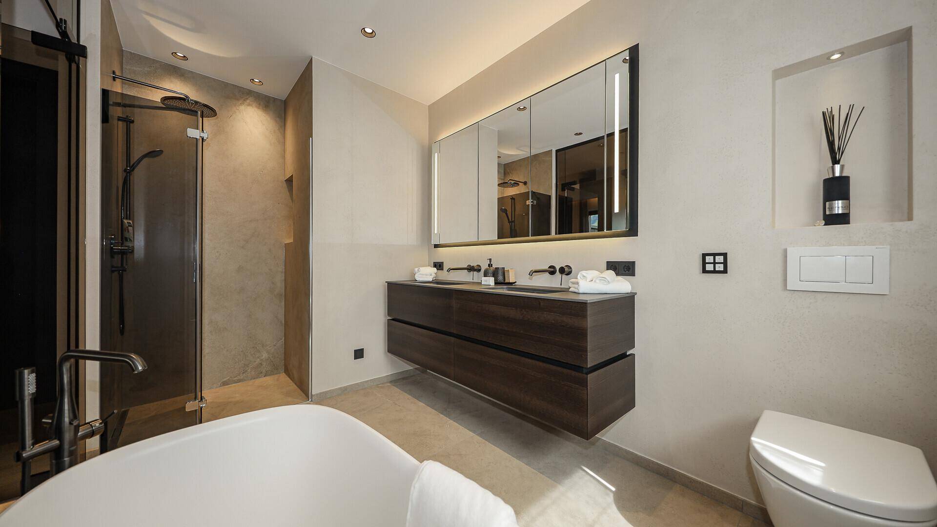 Elegantes Badezimmer mit begehbarer Dusche, freistehender Badewanne und Doppelwaschbecken.