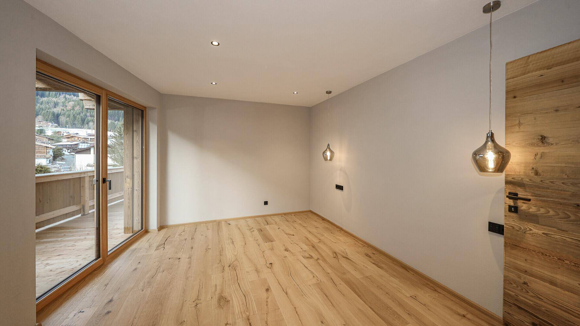 Helles Schlafzimmer mit Holzboden und Zugang zu einem Balkon, ideal für erholsame Nächte.