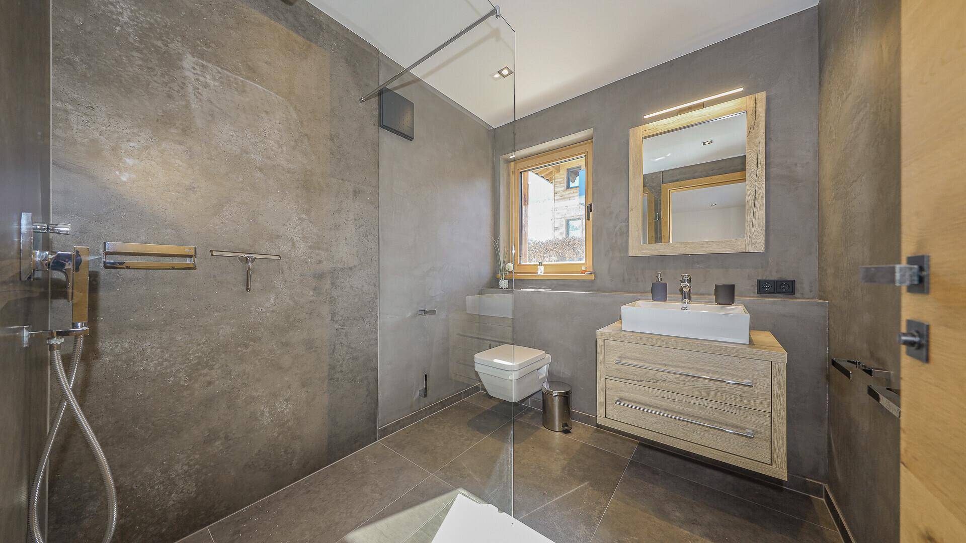 Modernes Badezimmer mit ebenerdiger Dusche, Wand-WC und Fenster.