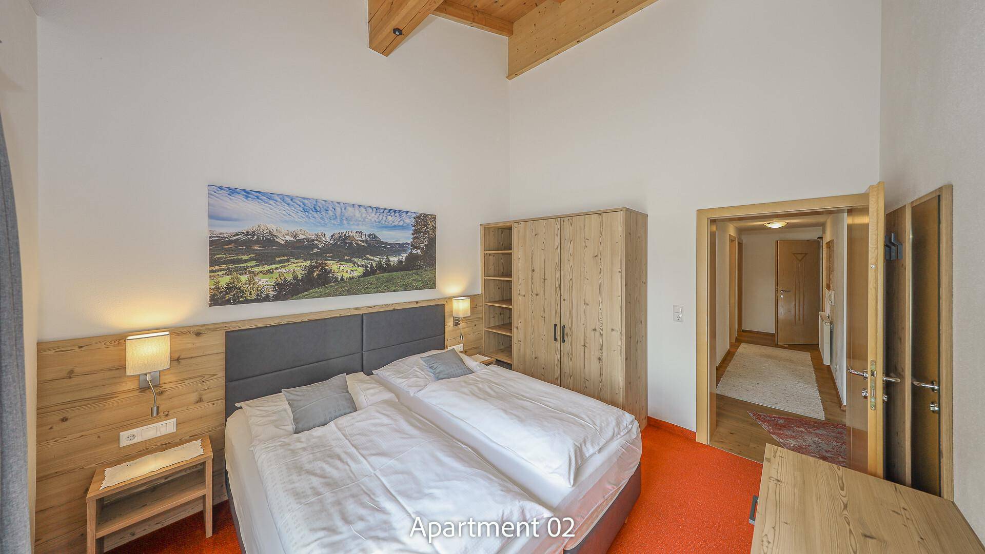 Geräumiges Schlafzimmer mit Doppelbett, Holzmöbeln und Teppichboden.