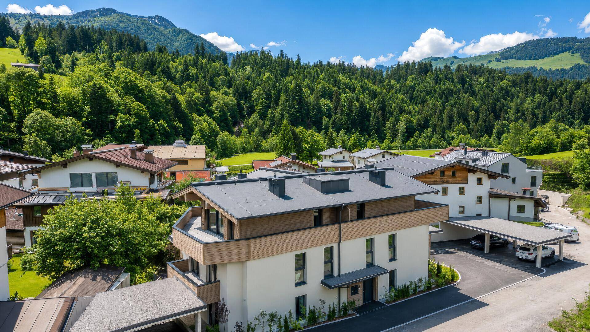 Panoramablick auf ein modernes Wohnhaus mit Flachdach und umliegender Berglandschaft.