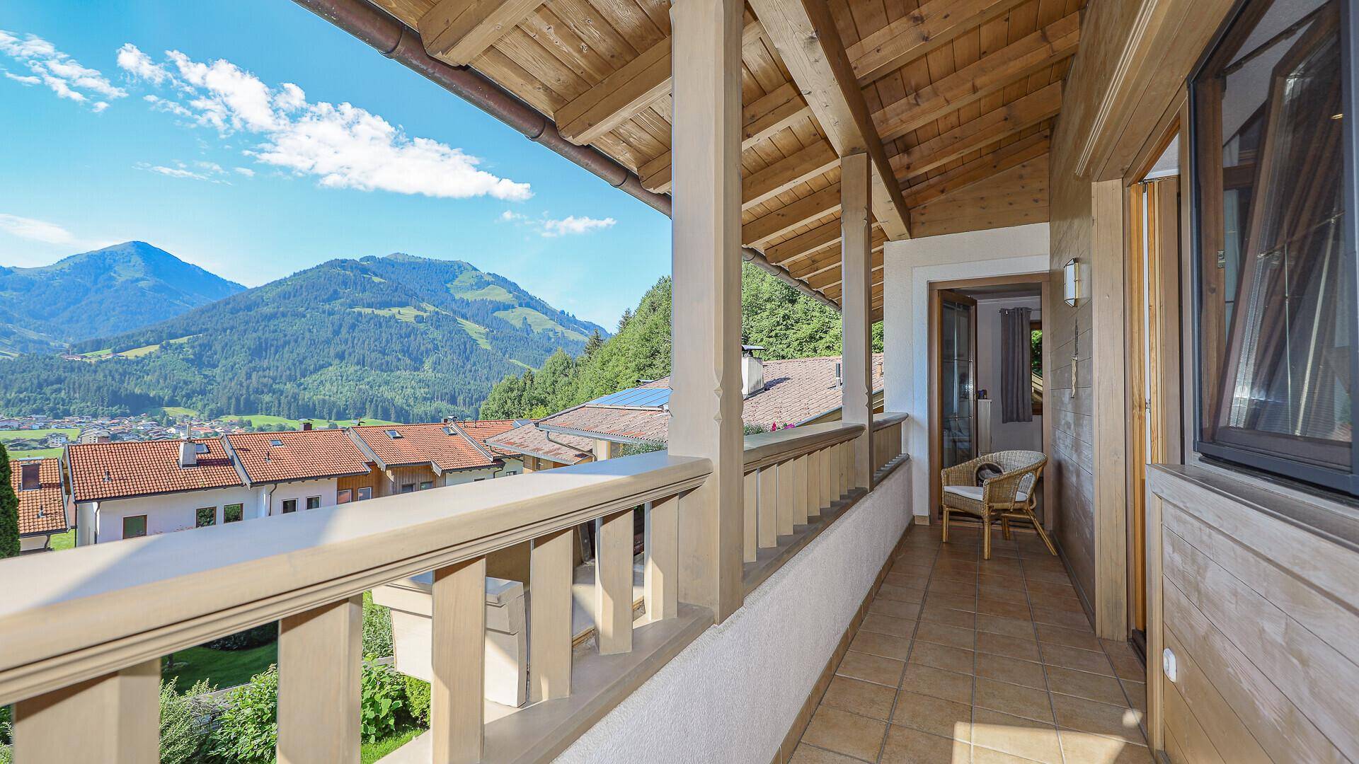 Geräumiger Balkon mit Holzgeländer und weitem Blick auf die alpine Landschaft.