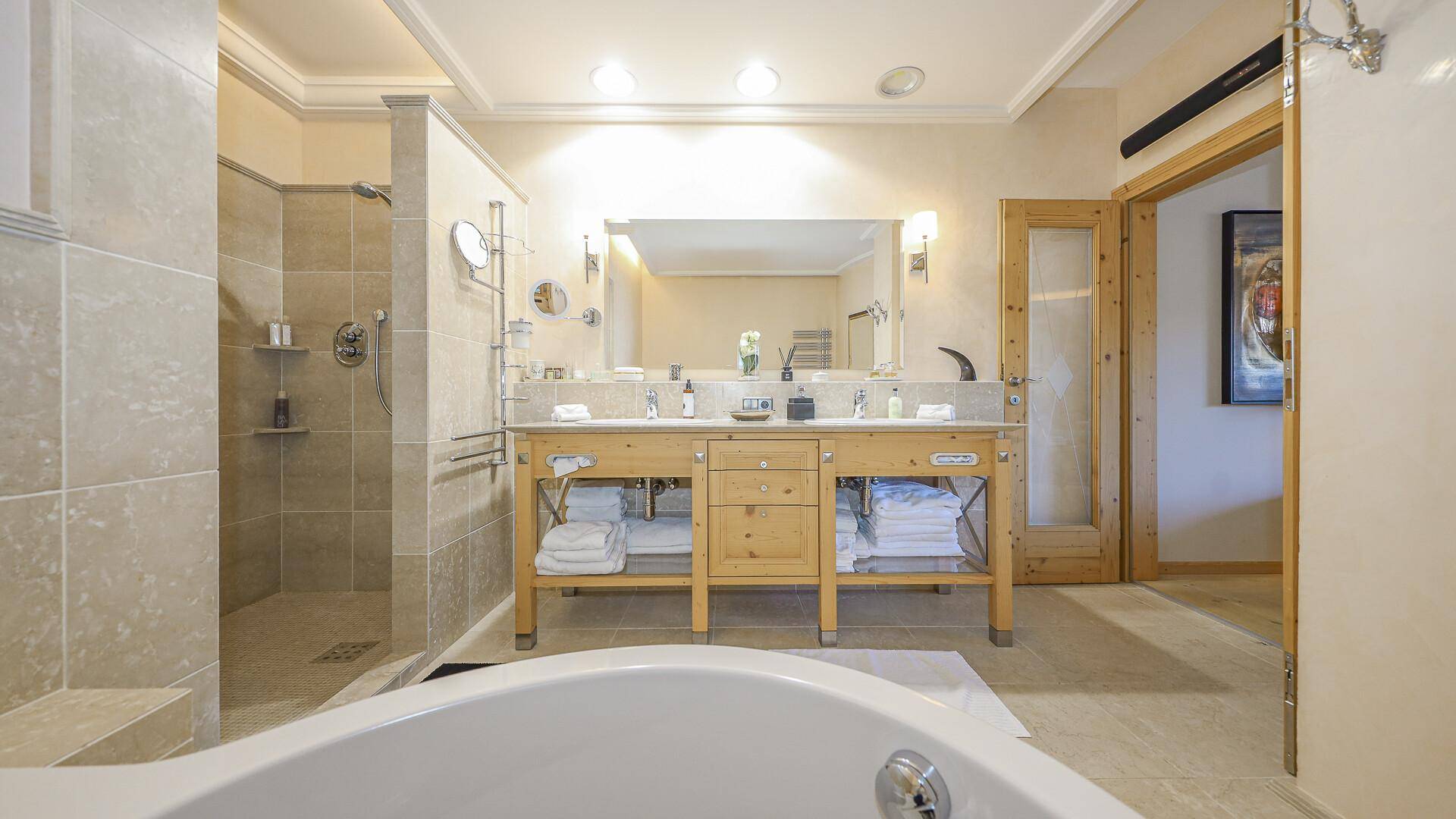 Geräumiges Badezimmer mit Doppelwaschbecken, großer Dusche und Badewanne.