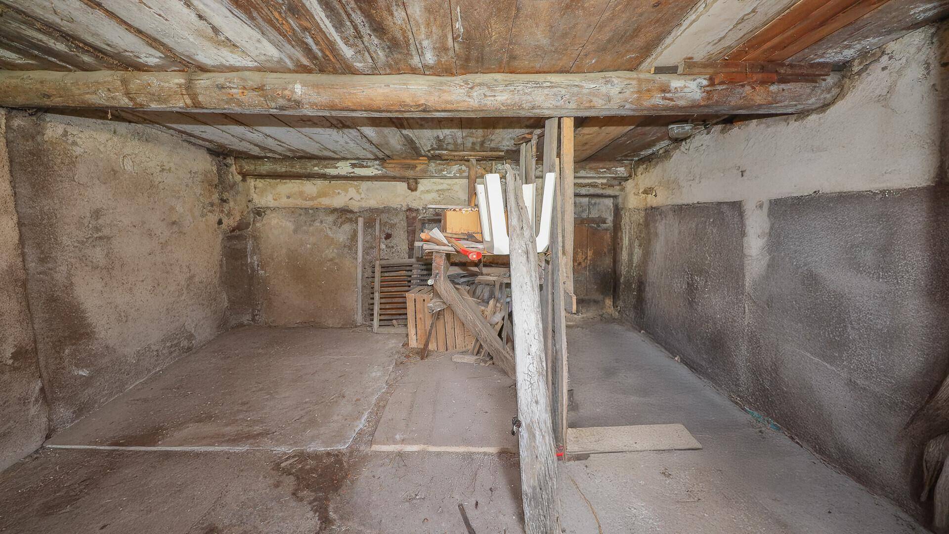 Unausgebauter Kellerraum mit Betonboden und rauen Wänden, geeignet als Lagerfläche.