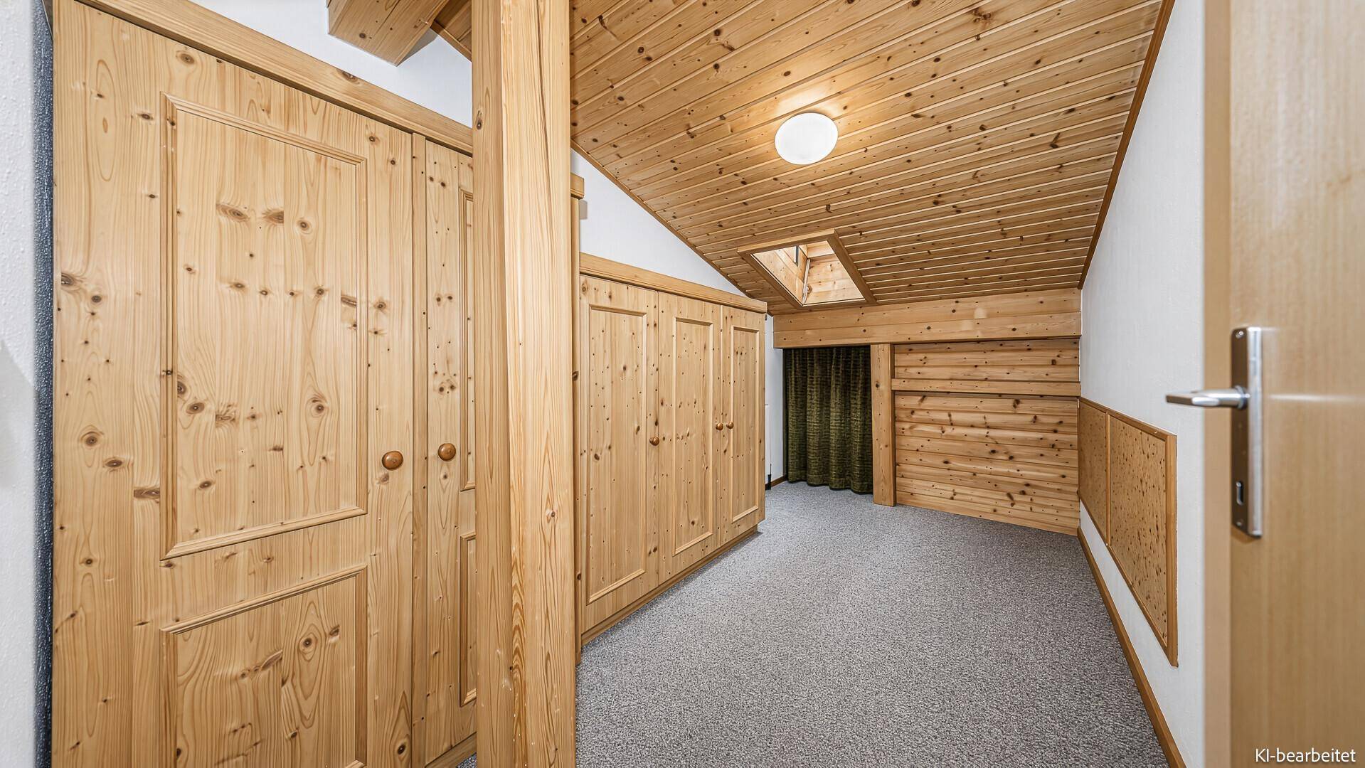 Geräumiges Zimmer mit Einbauschränken, Teppichboden und Holzbalkendecke im Dachgeschoss.