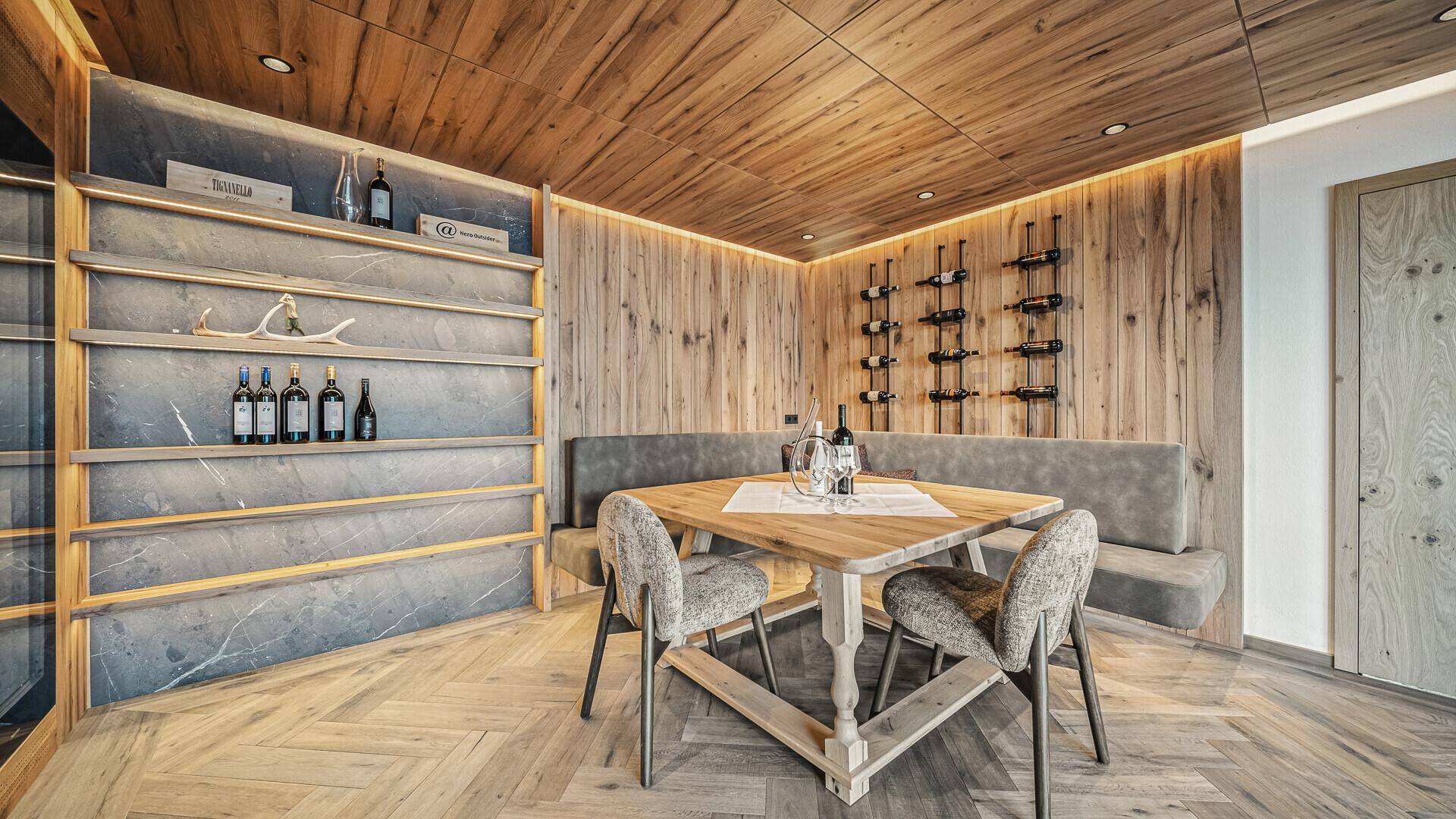 Gemütlicher Essbereich mit Weinregalen und Holzwänden, ideal für Weinliebhaber.