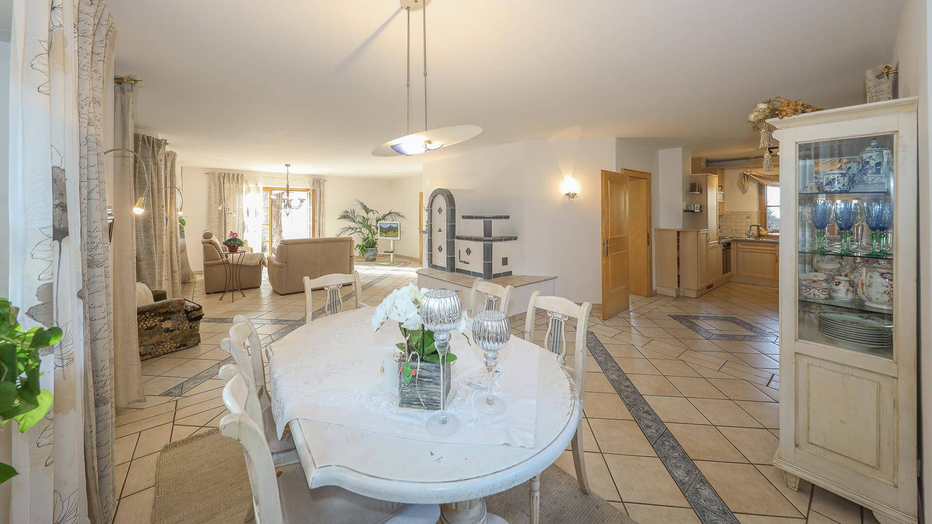 Geräumiger Essbereich mit großem Tisch, Vitrinenschrank und Blick in den Wohnbereich.