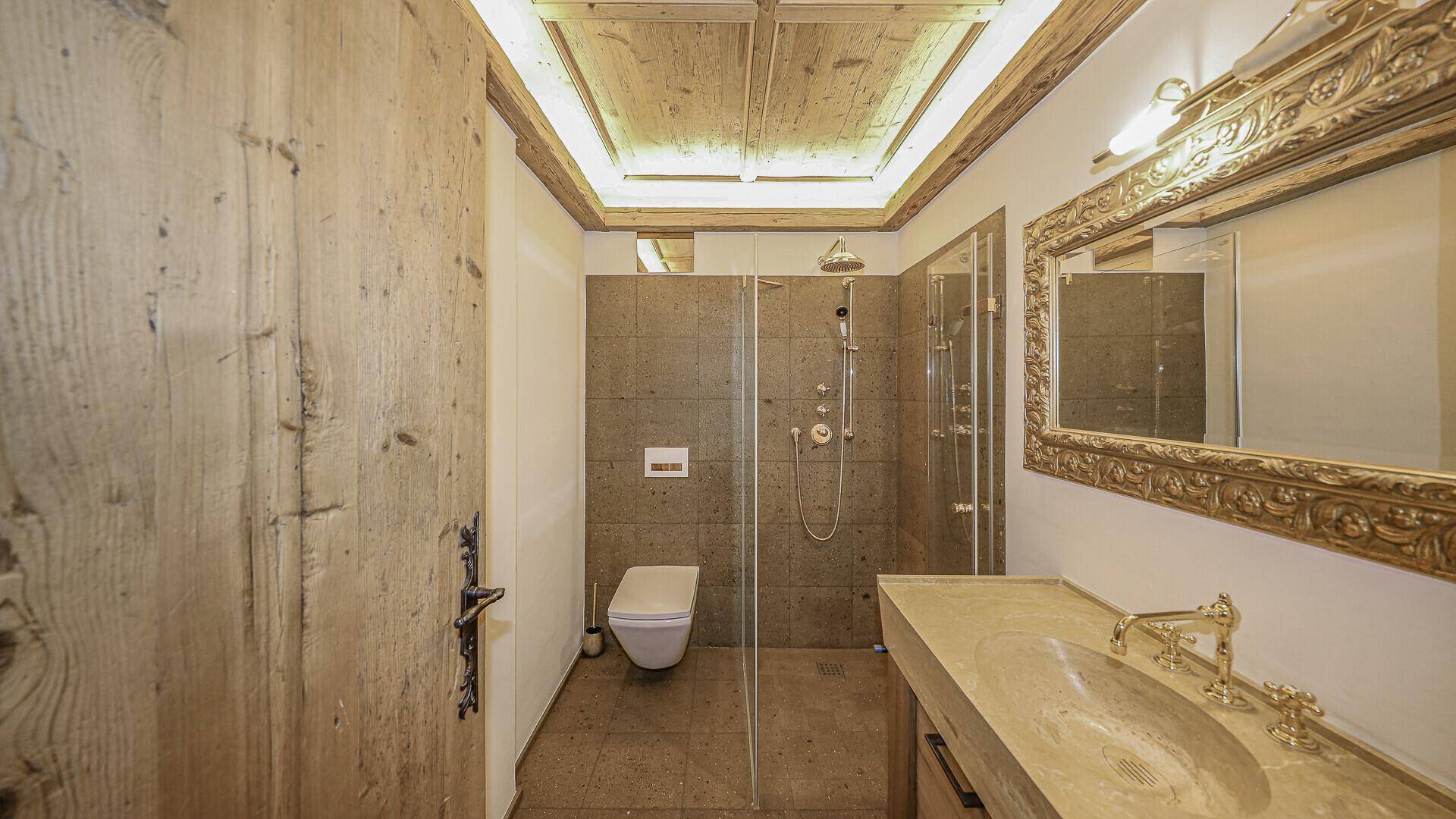 Modernes Badezimmer mit begehbarer Dusche, Wand-WC und großem Spiegel.