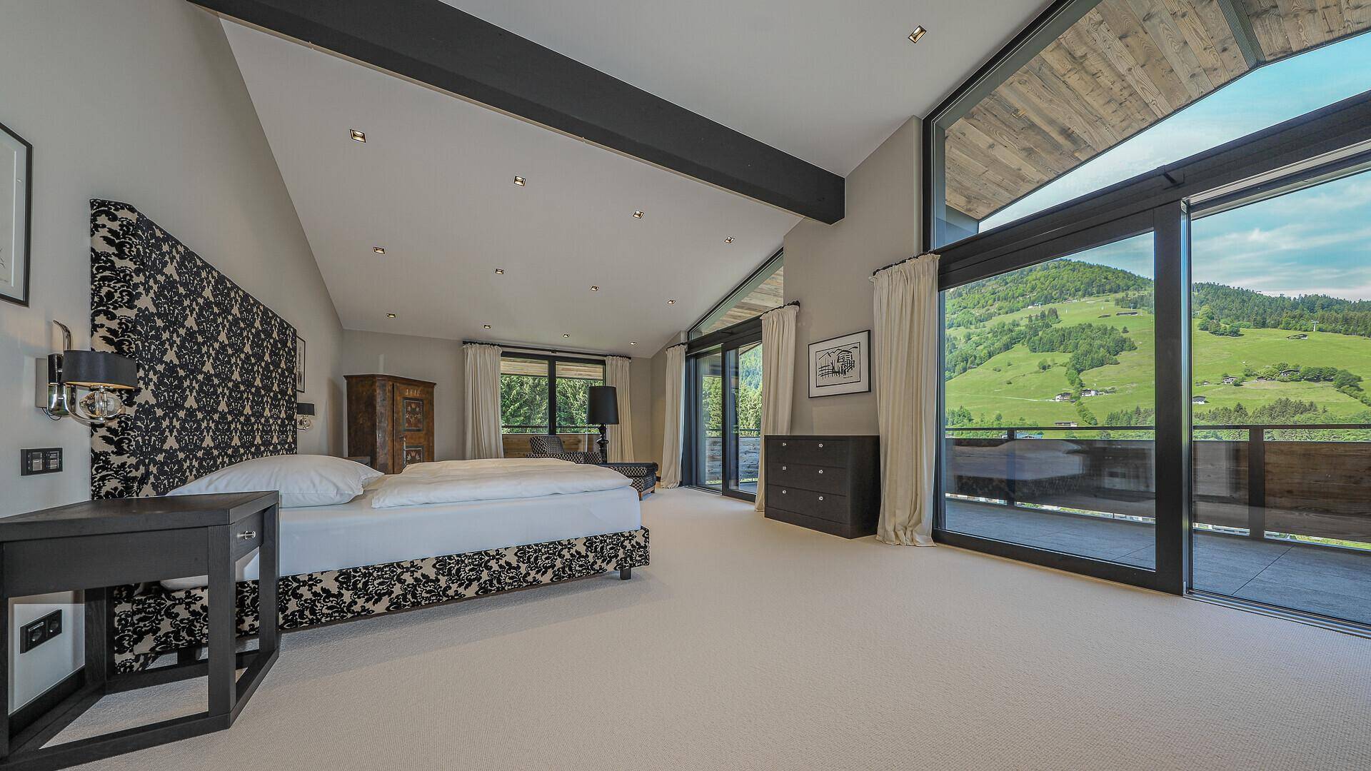 Großzügiges Schlafzimmer mit Balkonzugang und atemberaubendem Blick auf die Berge.