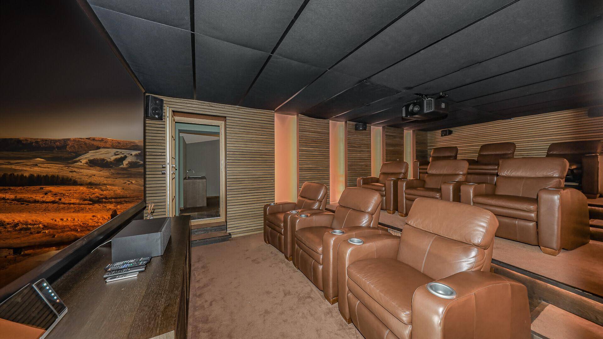 Exklusives Heimkino mit bequemen Ledersesseln und großer Leinwand für Filmerlebnisse.