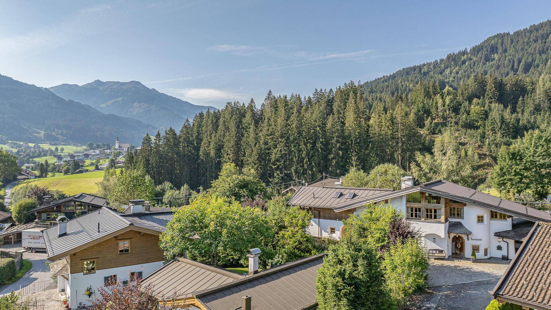 Weitläufiger Blick auf das Anwesen mit dichtem Wald und Bergen im Hintergrund.