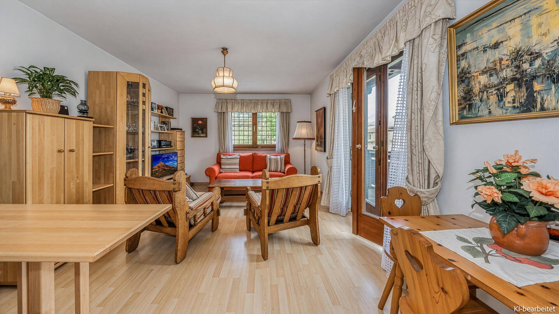 Geräumiger Wohn- und Essbereich mit rotem Sofa, Holzmöbeln und Zugang zum Balkon.