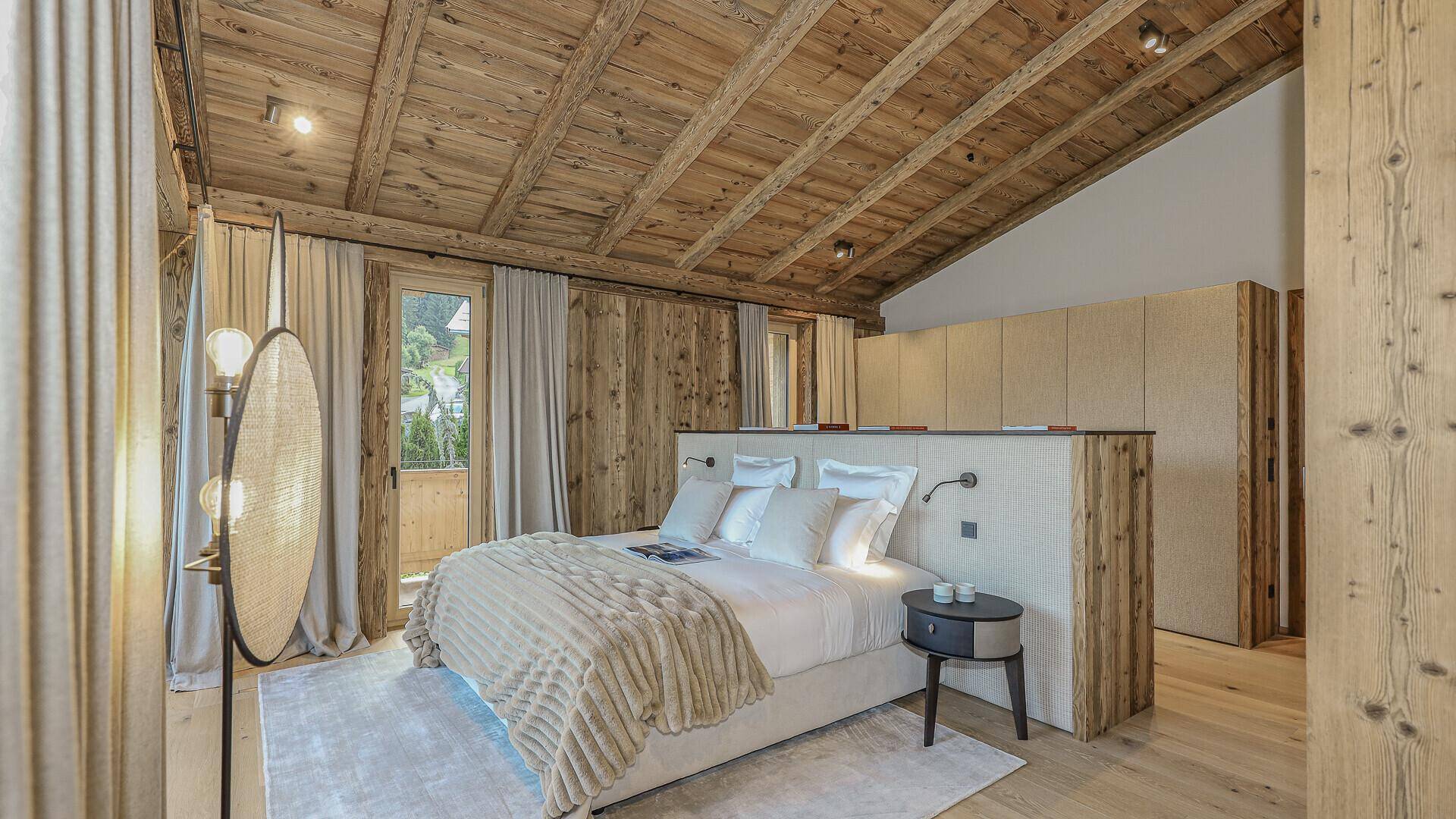 Gemütliches Schlafzimmer mit Holzwänden, integrierten Schränken und schrägem Dach.