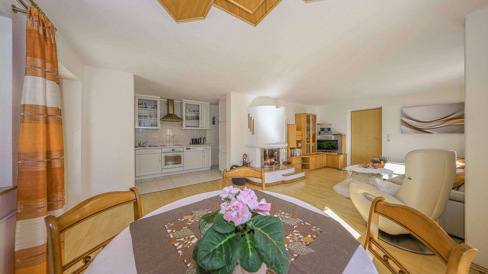 Gemütlicher Essbereich mit Blick auf die Küche und den Wohnbereich, ausgestattet mit Holzboden.