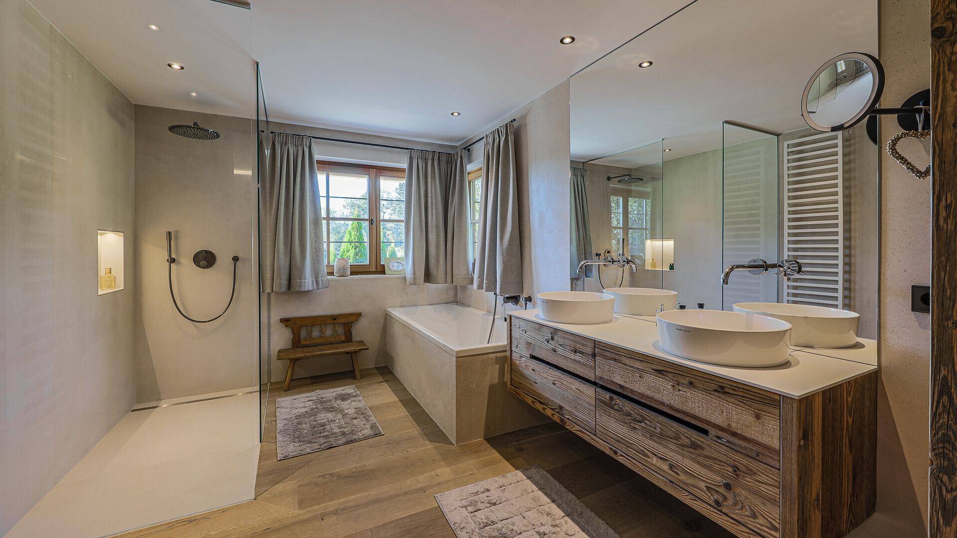 Geräumiges Badezimmer mit Doppelwaschbecken, Badewanne, begehbarer Dusche und Fenster.