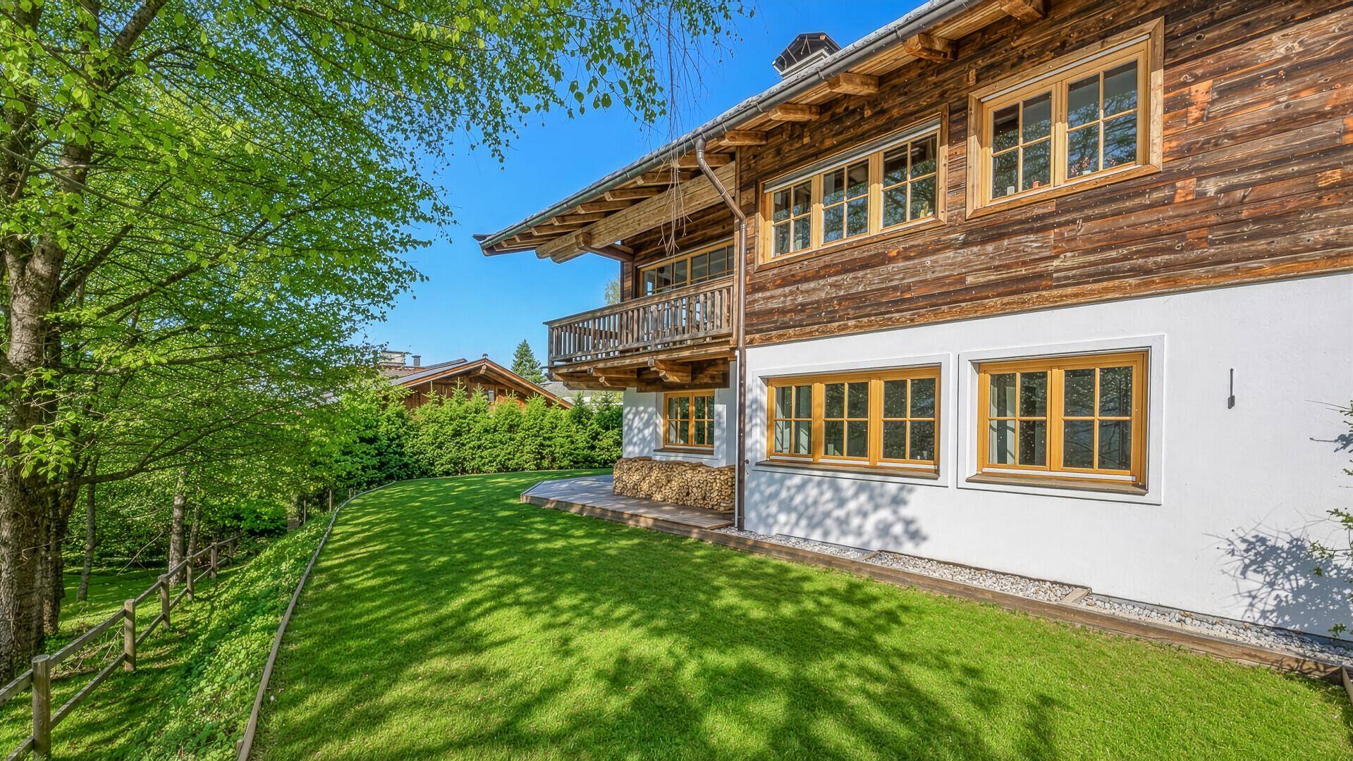 Gepflegte Rasenfläche neben dem Haus mit Blick auf die umliegende Natur.
