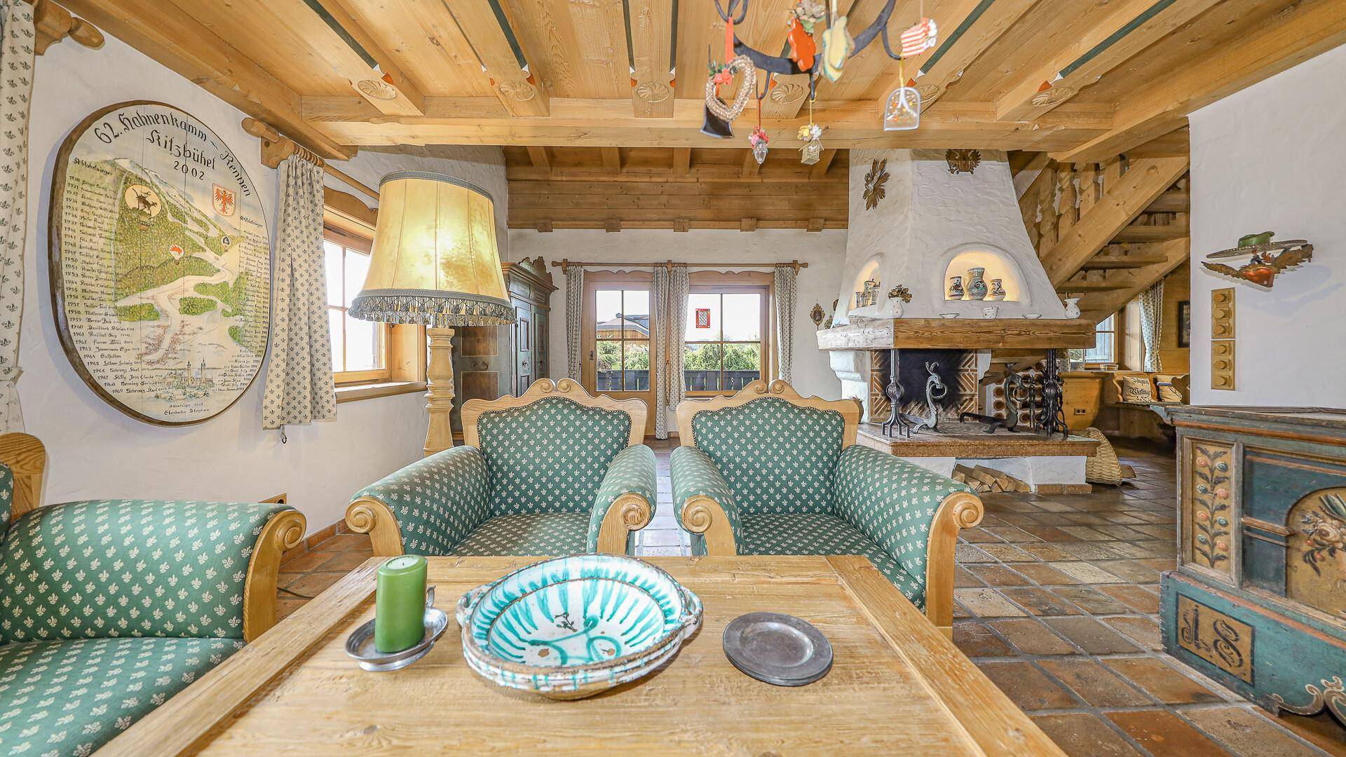 Gemütliches Wohnzimmer mit traditionellen Möbeln, Kamin und Blick ins Grüne.