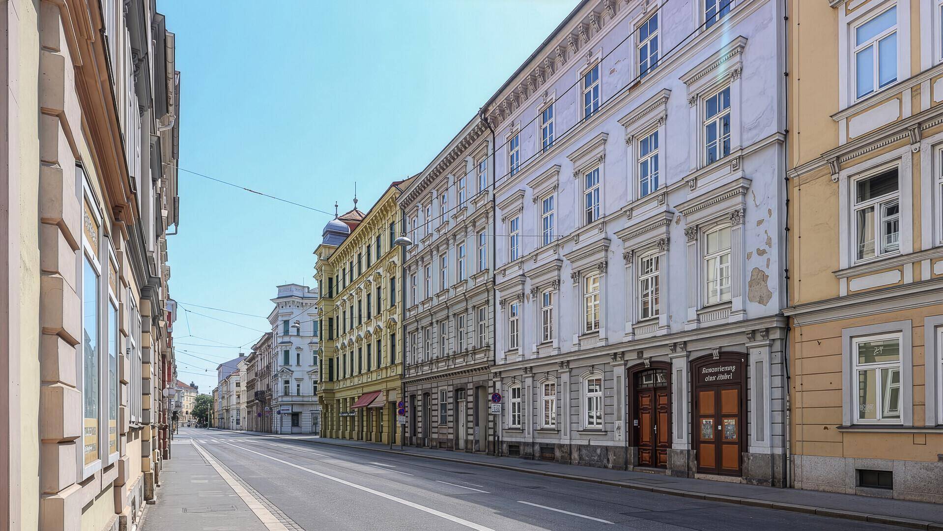 Historische Straßenansicht mit mehreren Gebäudefassaden und einer leeren Straße.