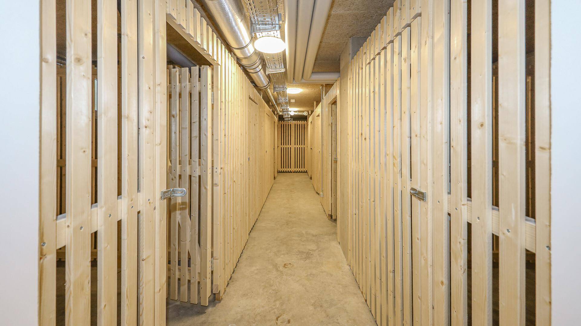 Kellerabteile mit Holzlattenwänden bieten praktischen Stauraum für Bewohner.