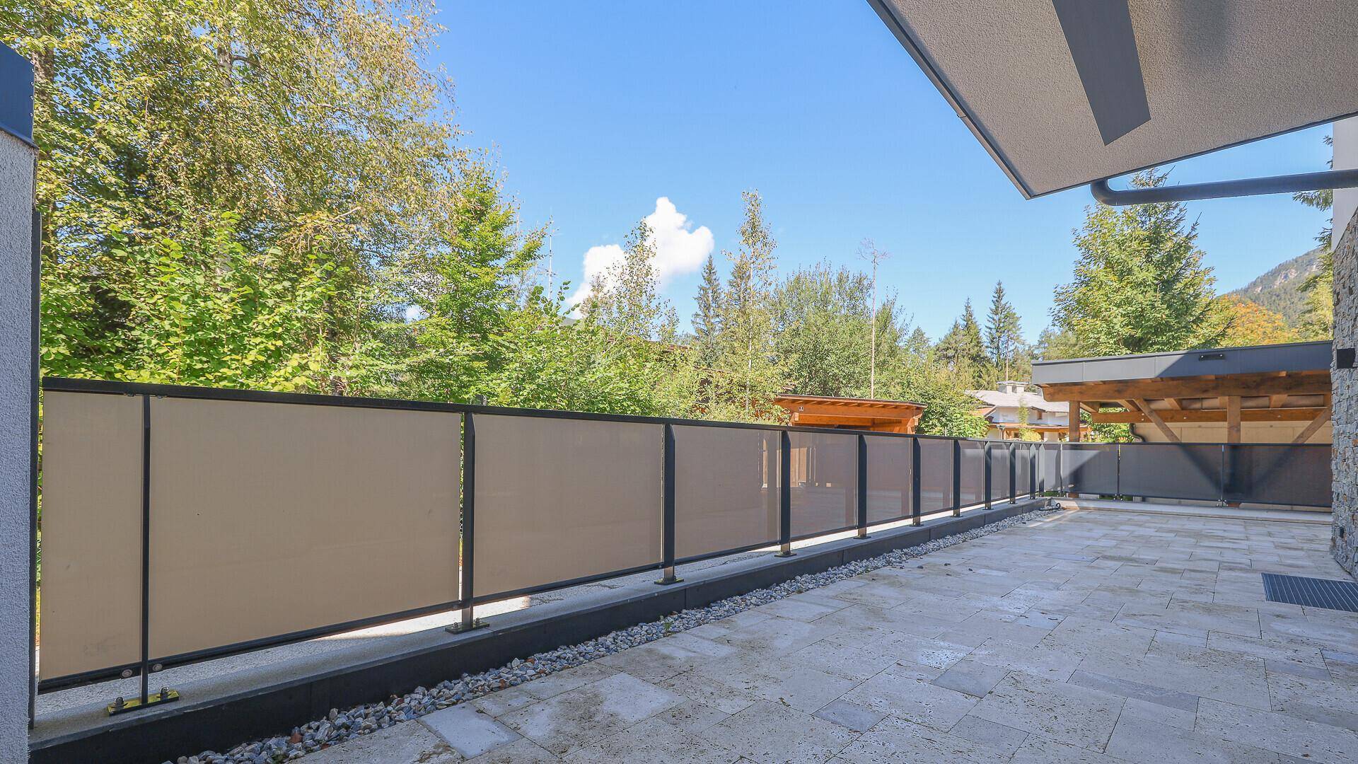 Große gepflasterte Terrasse mit Blick auf die umliegende Natur und Berge.
