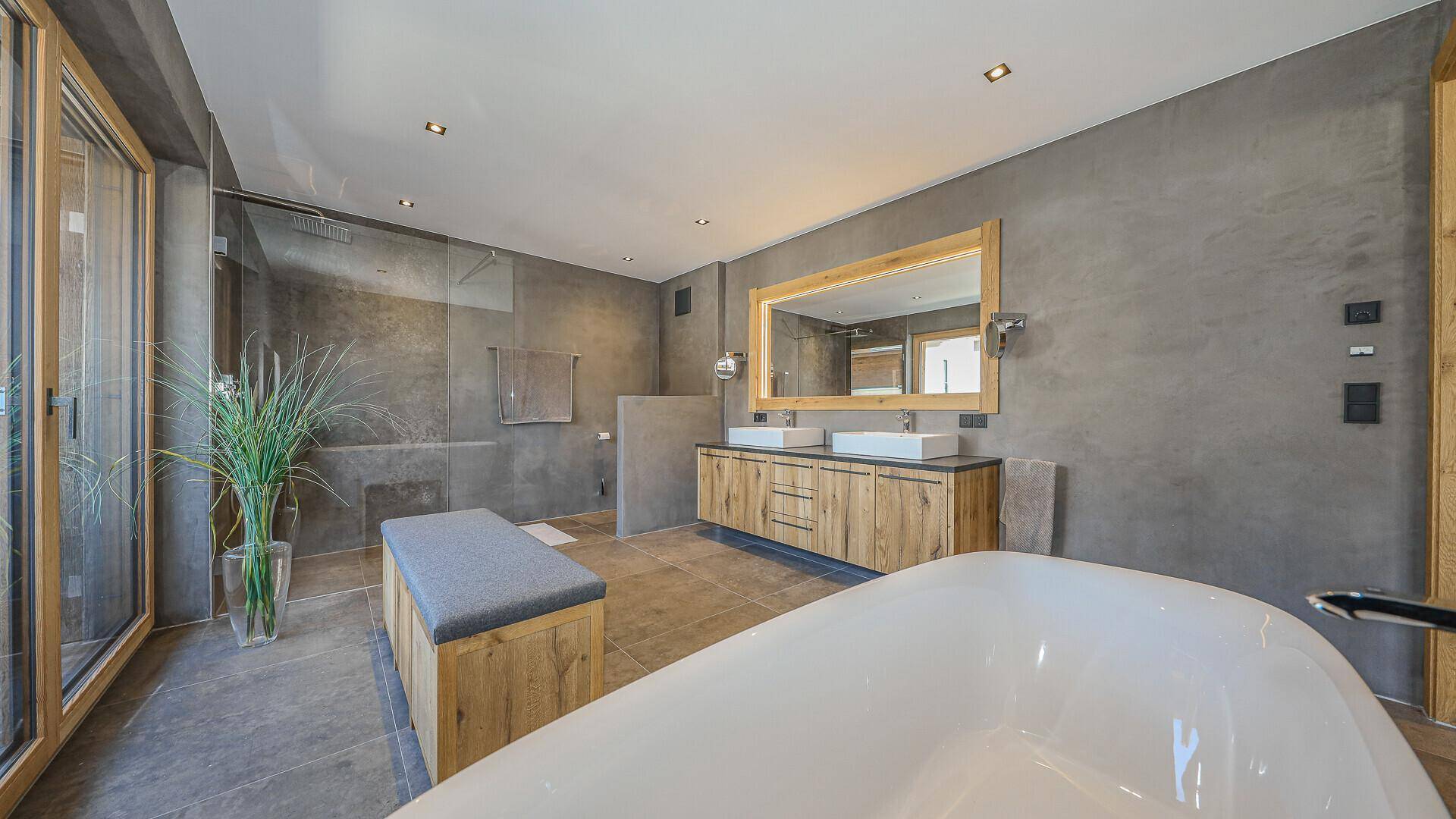 Modernes Badezimmer mit freistehender Badewanne, Doppelwaschbecken und großer Dusche.