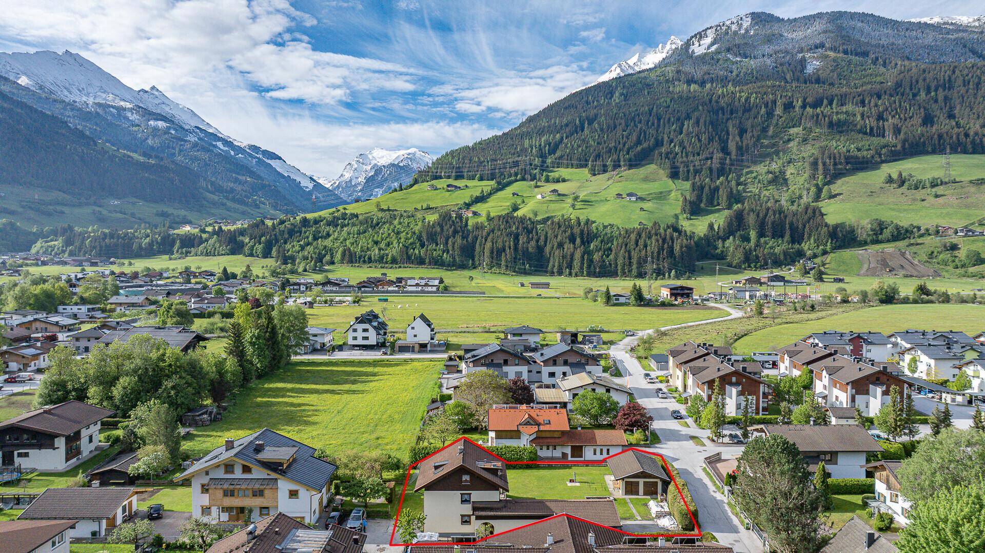 Idyllisches Anwesen mit Garten und Bergblick, eingebettet in eine grüne Tallandschaft.