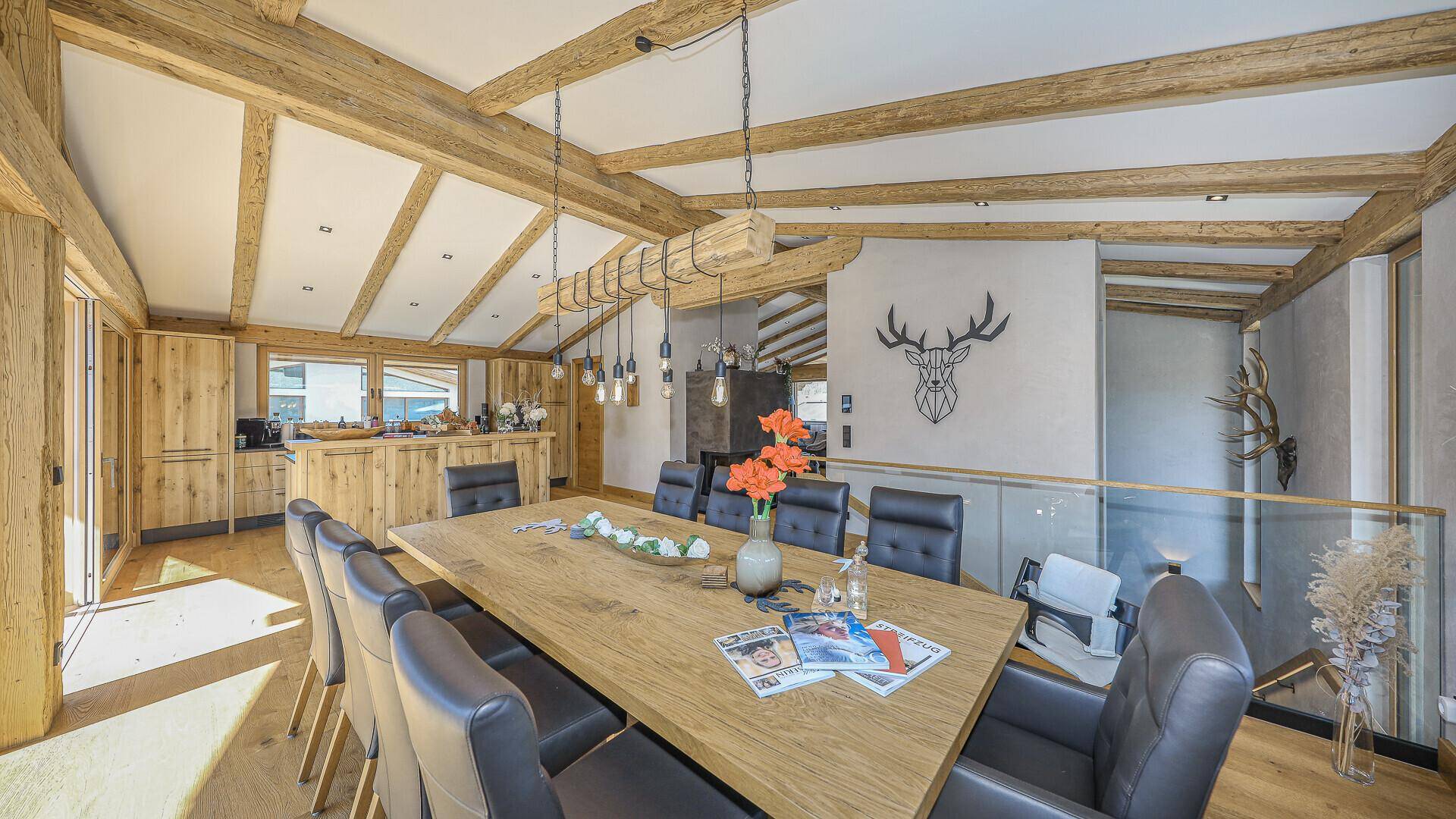 Großer Essbereich mit Holztisch, modernen Stühlen und Hirschgeweih-Dekoration.