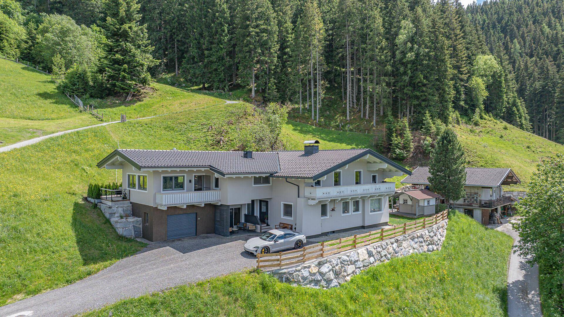 Großzügiges Einfamilienhaus in alpiner Landschaft mit weitläufigem Grundstück und Bergblick.
