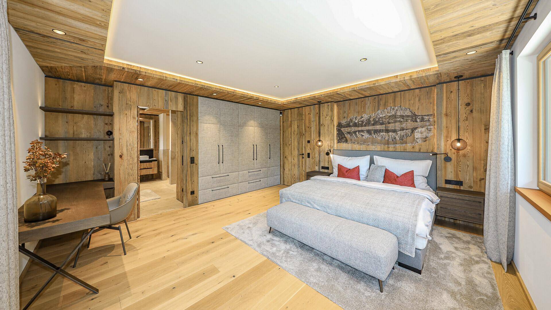 Gemütliches Schlafzimmer im alpinen Stil mit Holzwänden, Einbauschränken und Doppelbett.