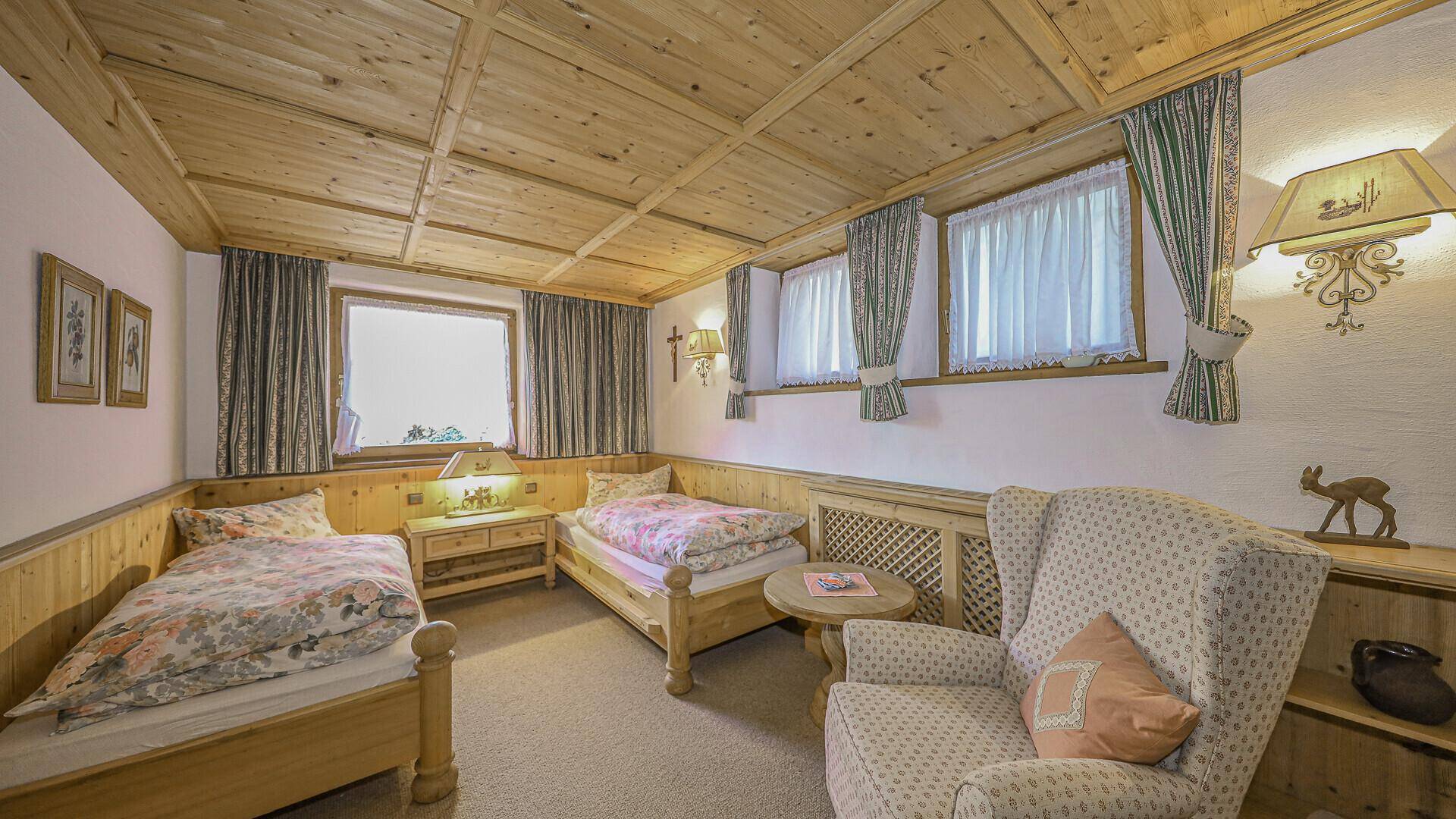 Gemütliches Schlafzimmer mit zwei Einzelbetten, Holzdecke und traditioneller Einrichtung.