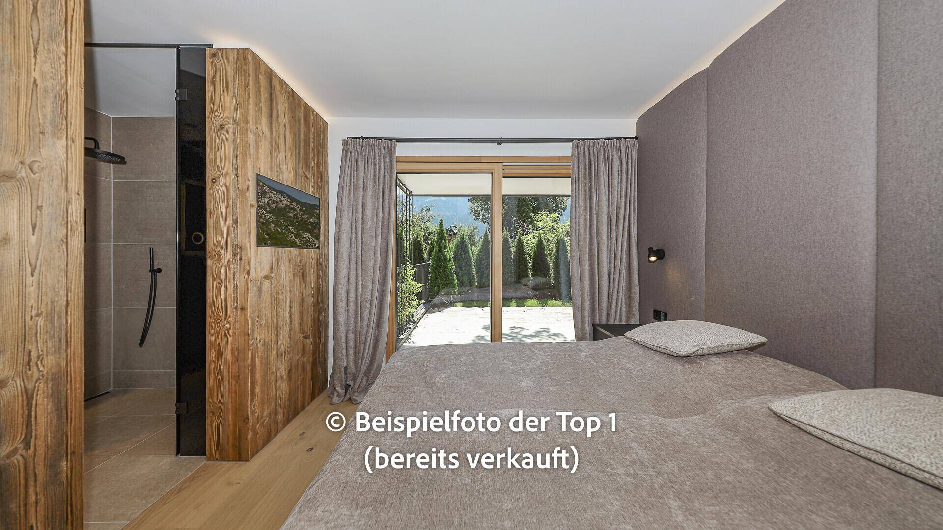 Modernes Schlafzimmer mit Holzwänden, integrierter Dusche und Zugang zum Gartenbereich.
