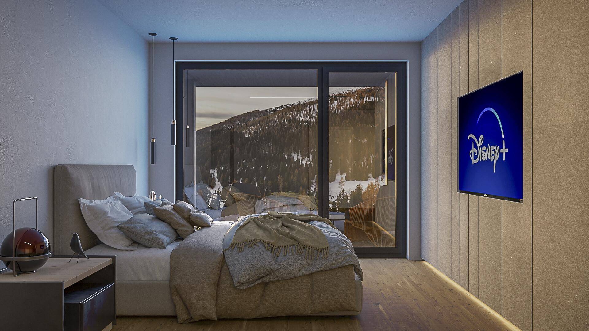Schlafzimmer mit großem Fenster, das einen weiten Blick auf die schneebedeckten Berge bietet.