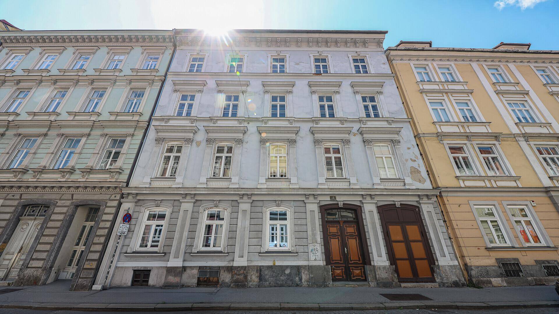 Detailansicht der historischen Gebäudefassade mit vielen Fenstern und Eingangstüren.