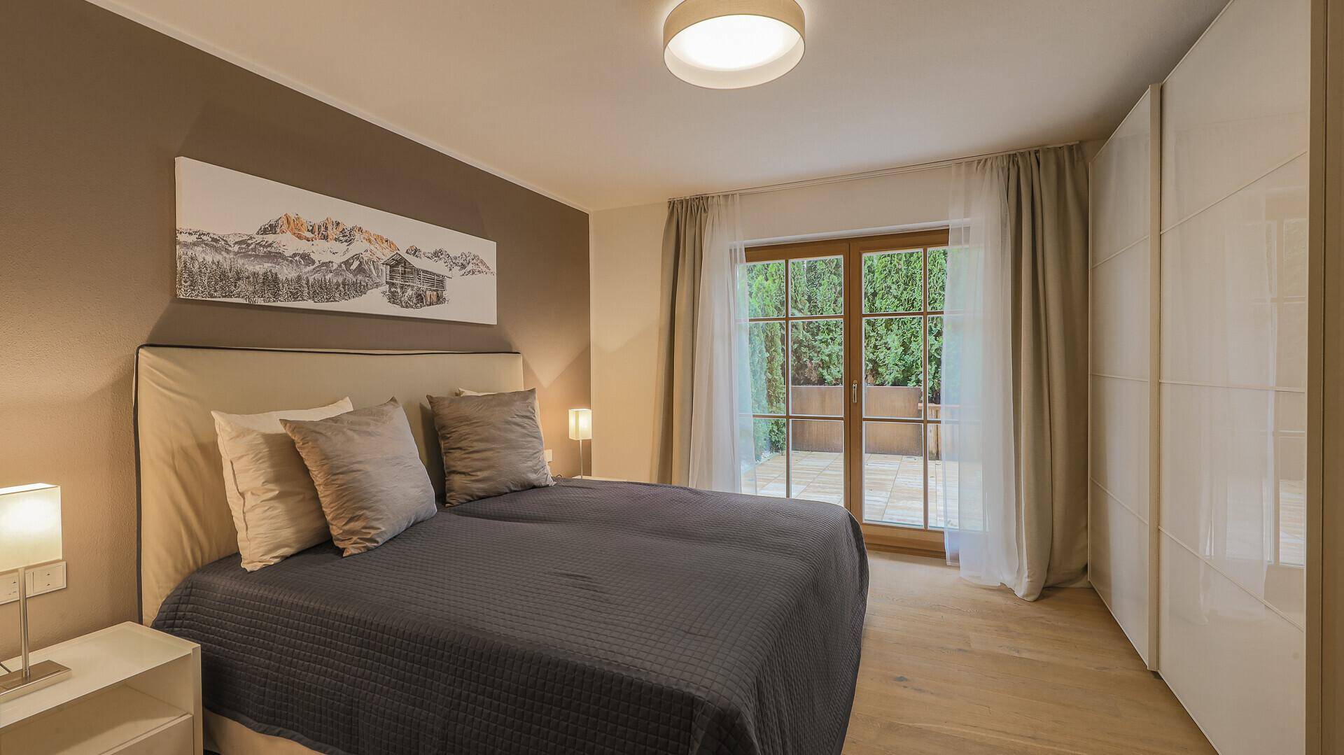Helles Schlafzimmer mit Einbauschränken und direktem Zugang zu einer privaten Terrasse.