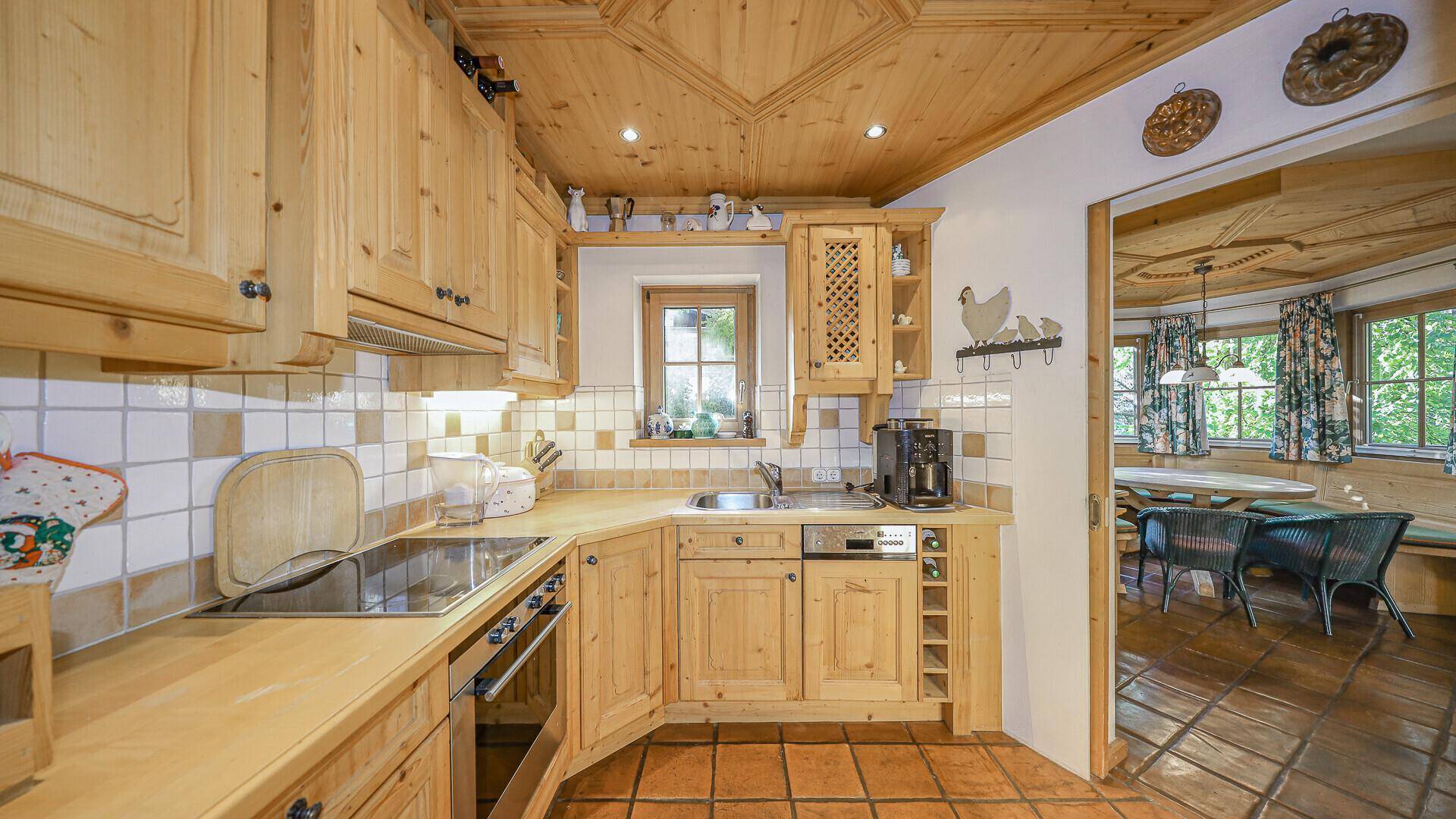Rustikale Holzküche mit traditionellen Fliesen, Einbaugeräten und Fensterblick.