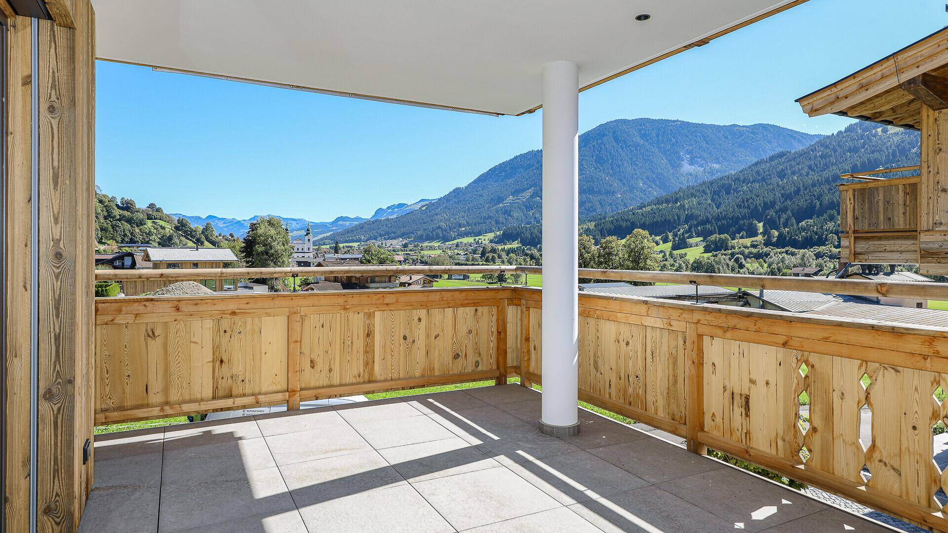 Weitläufige Terrasse mit Holzgeländer und atemberaubendem Panoramablick auf die umliegenden Berge.