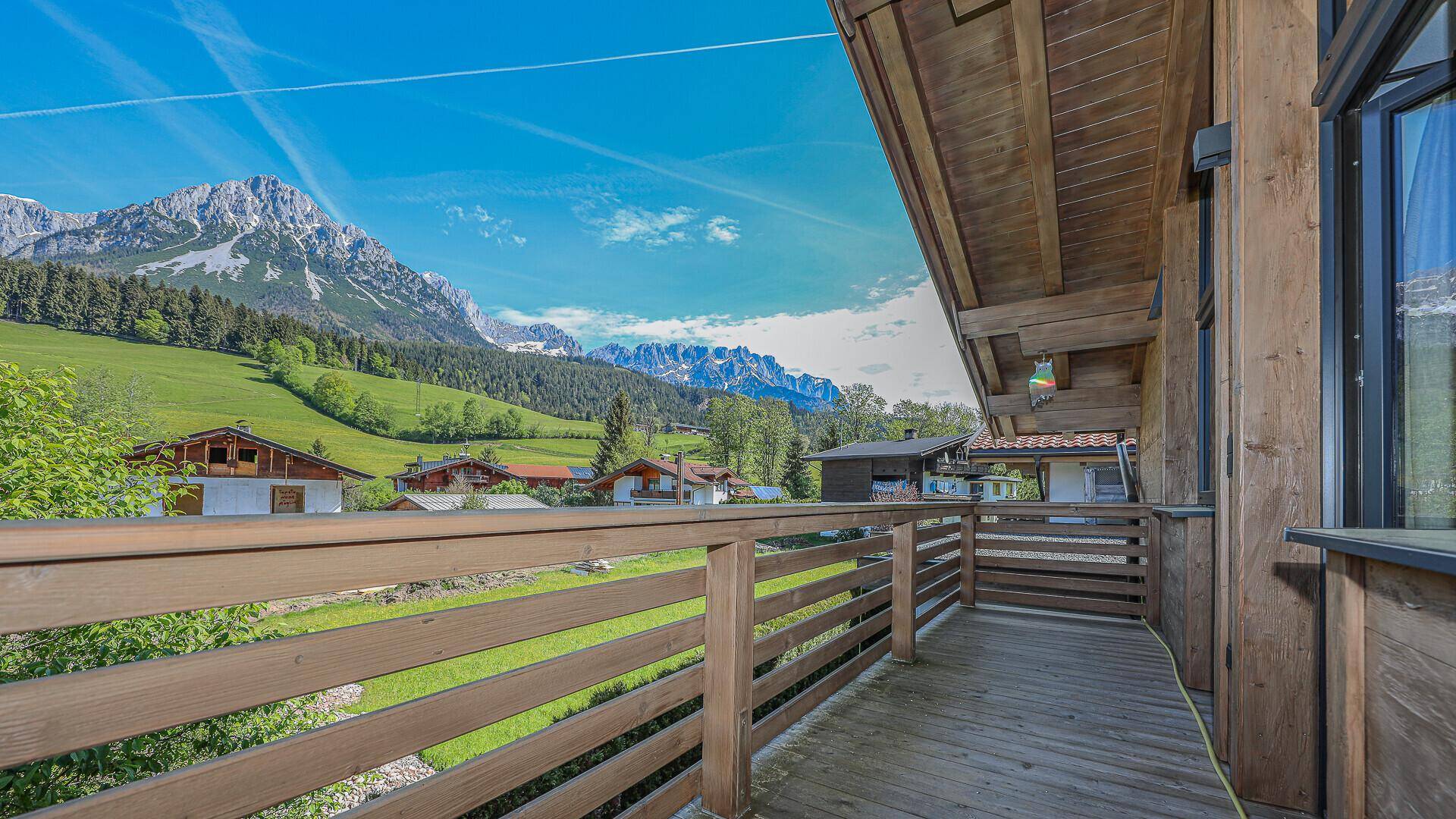 Holzbalkon mit Geländer und atemberaubendem Panoramablick auf die umliegende Bergwelt.