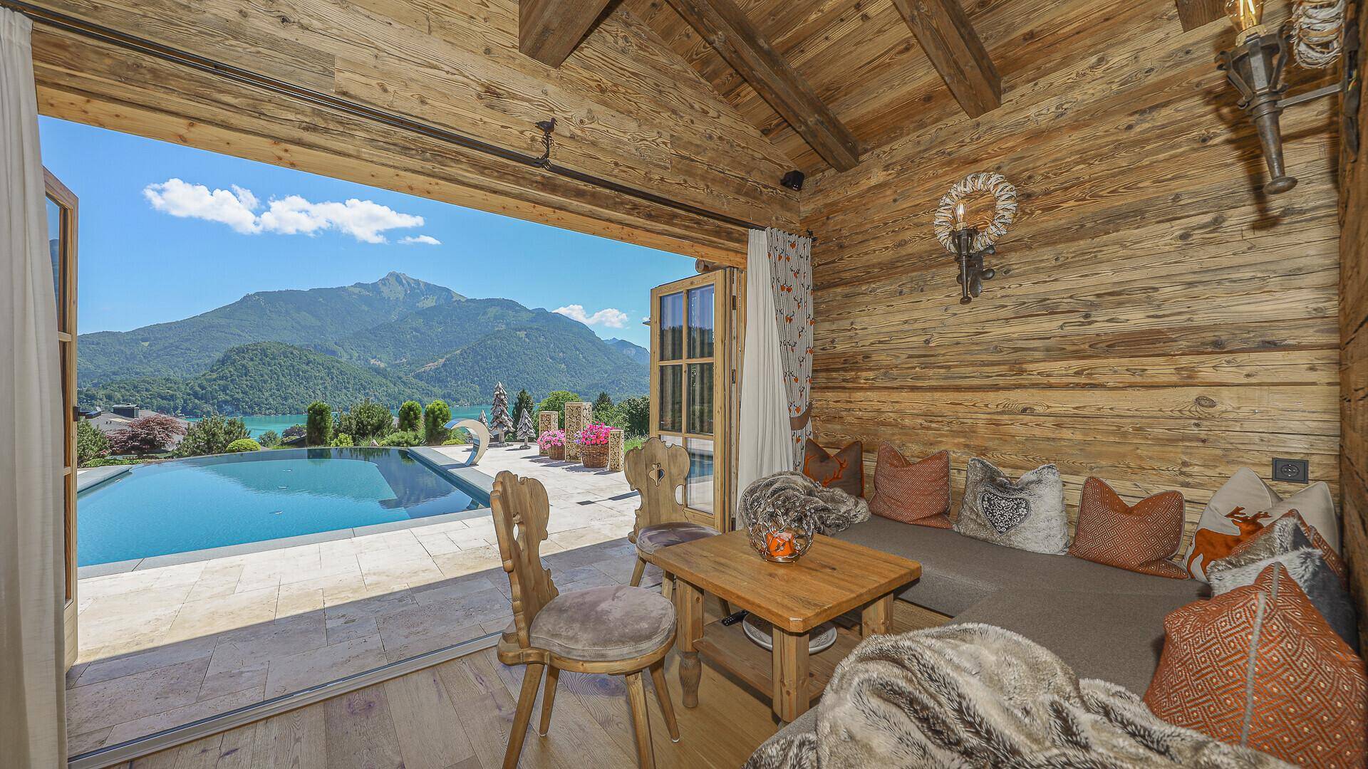 Entspannungsbereich im Holzhaus mit Holztäfelung, gemütlicher Sitzecke und Seeblick.