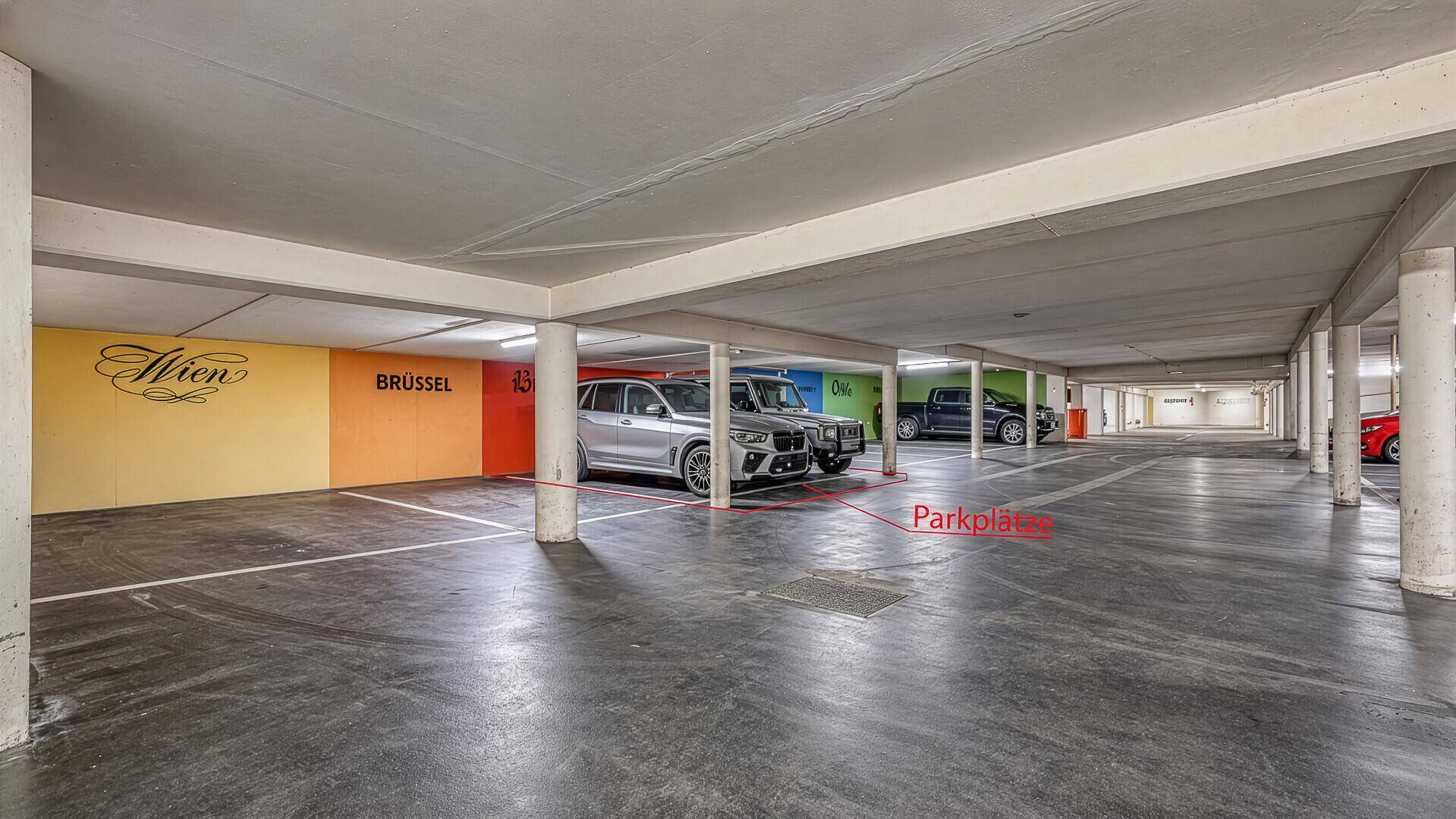 Tiefgarage mit mehreren Stellplätzen und farbigen Wandakzenten.