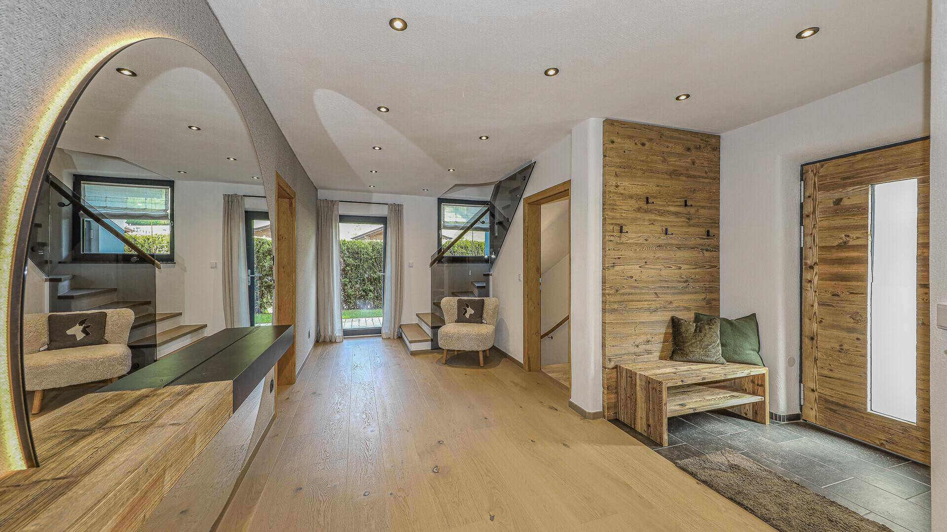 Heller Eingangsbereich mit Holzelementen, Sitzbank und Garderobe.