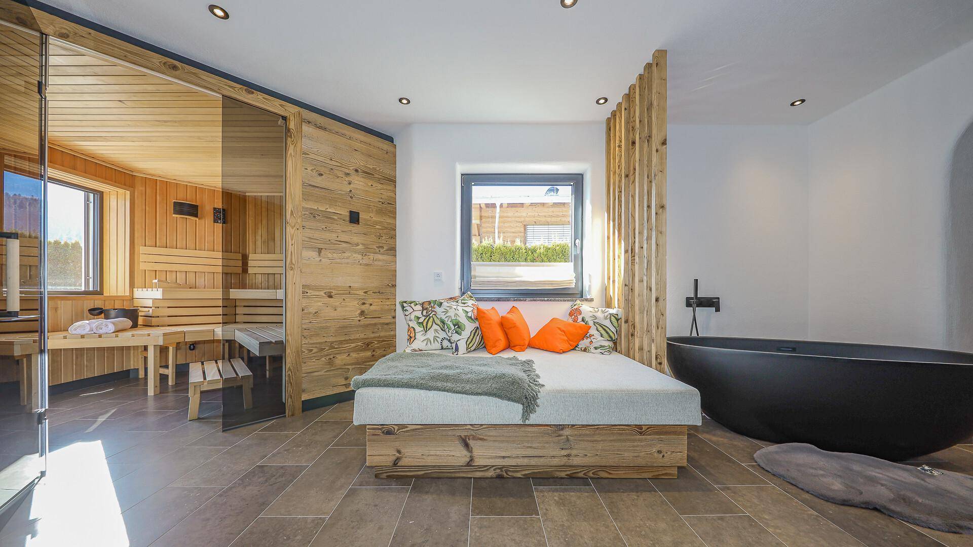 Privater Wellnessbereich mit Sauna, Liege und freistehender Badewanne für pure Entspannung.