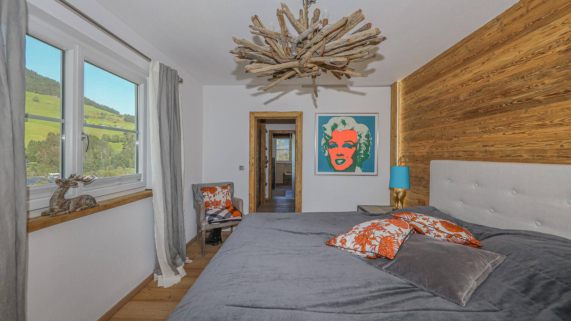 Schlafzimmer mit Holzwand, Doppelbett und Pop-Art-Bild, bietet einen schönen Ausblick.