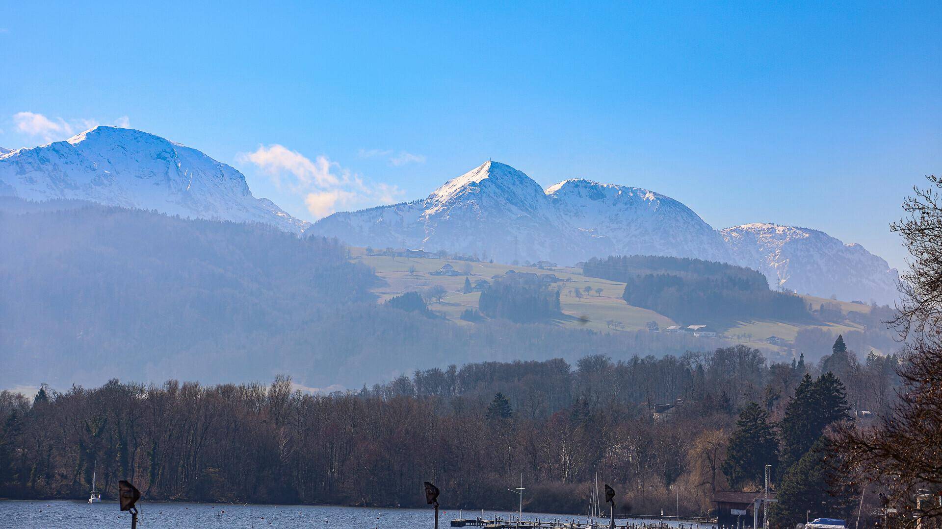 Weitläufiger Blick auf die majestätischen schneebedeckten Berge und die grüne Landschaft.